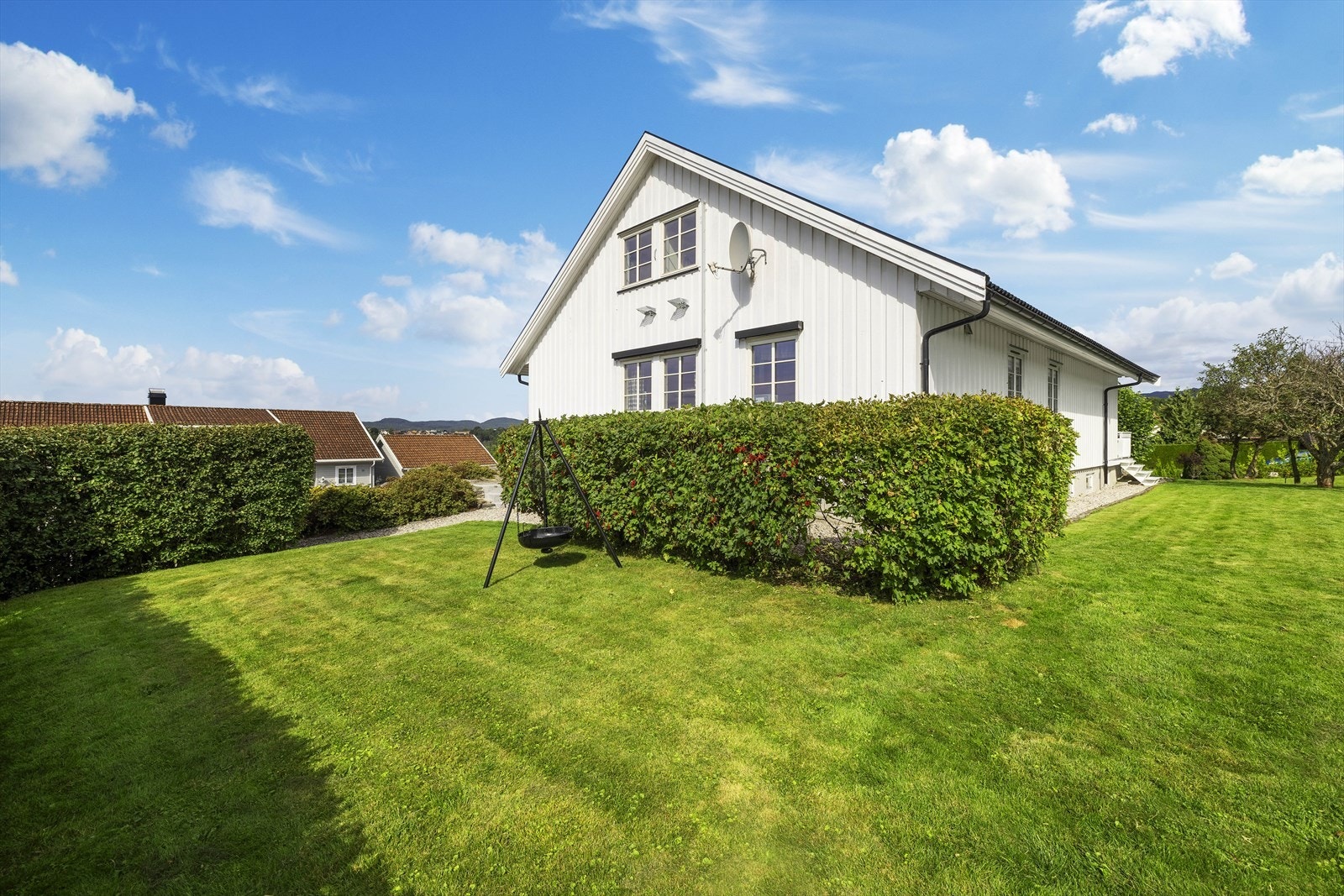 Eiendommen ligger på en solrik og romslig tomt som er pent opparbeidet med gressplen, prydbusker og beplantning Galleribilde