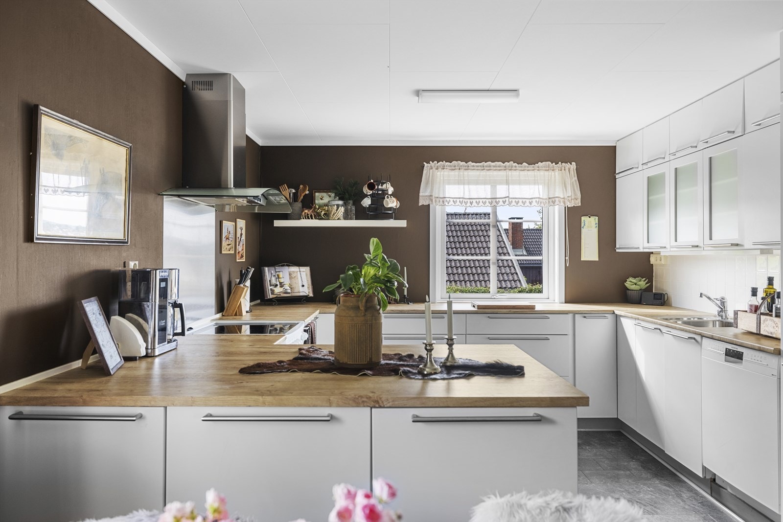 Kjøkkenet fremstår lyst og praktisk med god skap- og benkeplass Galleribilde