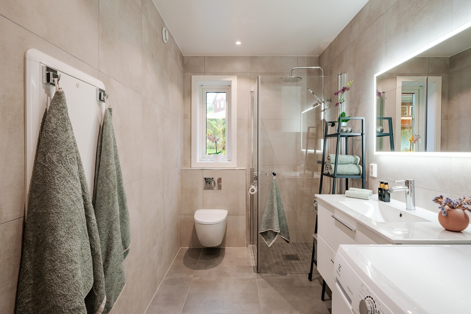 Badet er fra 2021 og har en moderne utførelse med flislagte gulv og vegger, samt himling med downlights. Galleribilde