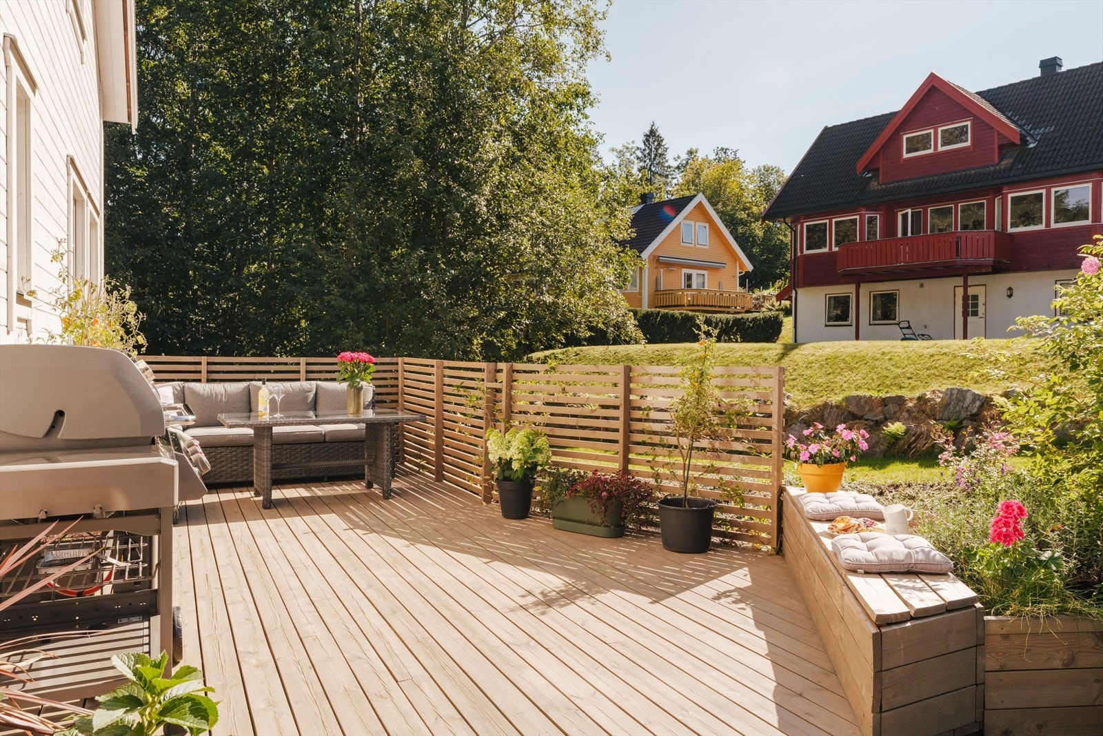 Området er opparbeidet med blomsterkasser og spilevegg som skaper en lun ramme rundt uteplassen. Galleribilde