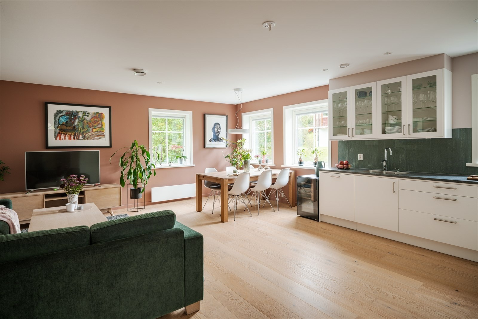 Stue og spisestue ligger i et åpent rom med vinduer på to vegger som slipper inn rikelig med naturlig lys. Himlingen er malt og har downlights. Galleribilde