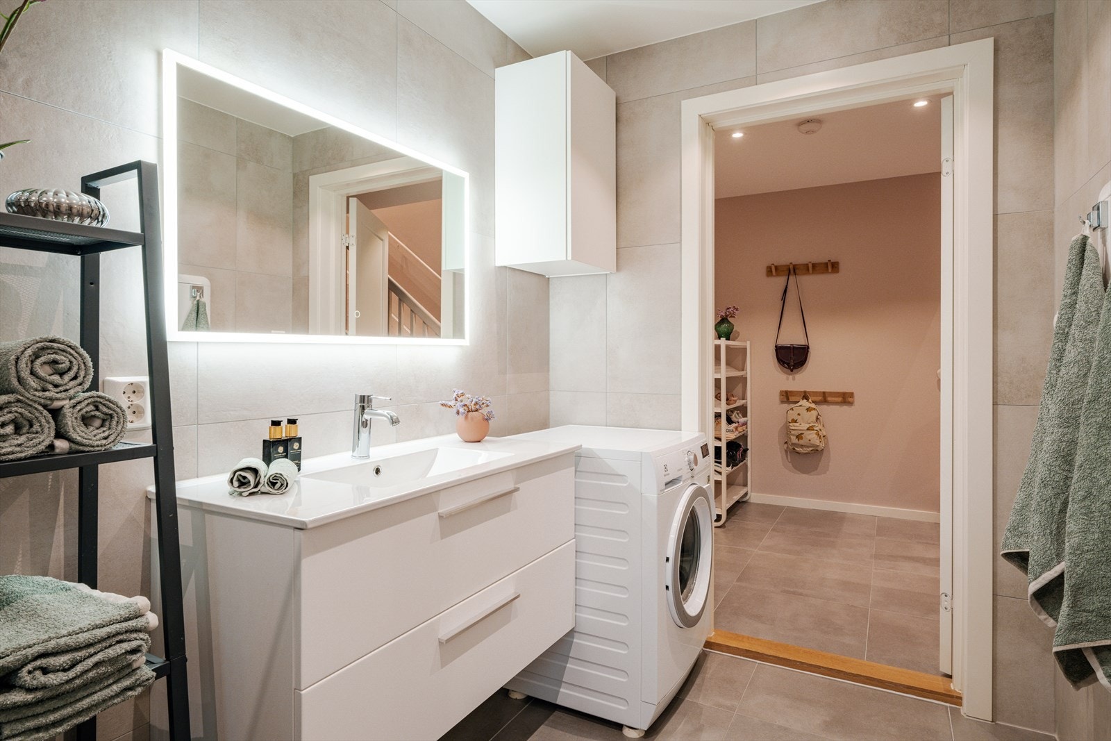 Det er veggmontert toalett, opplegg for vaskemaskin og et servantskap med blandebatteri fra Grohe. Galleribilde