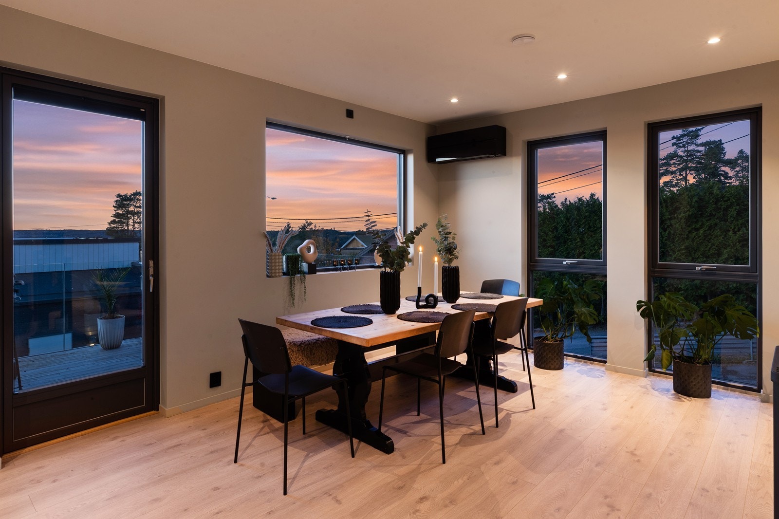 Flere store vindusflater slipper inn mye naturlig dagslys/kveldssol, i tillegg er det utgang til veranda her. I denne delen av stua, er det også montert varmepumpe for effektiv oppvarming Galleribilde