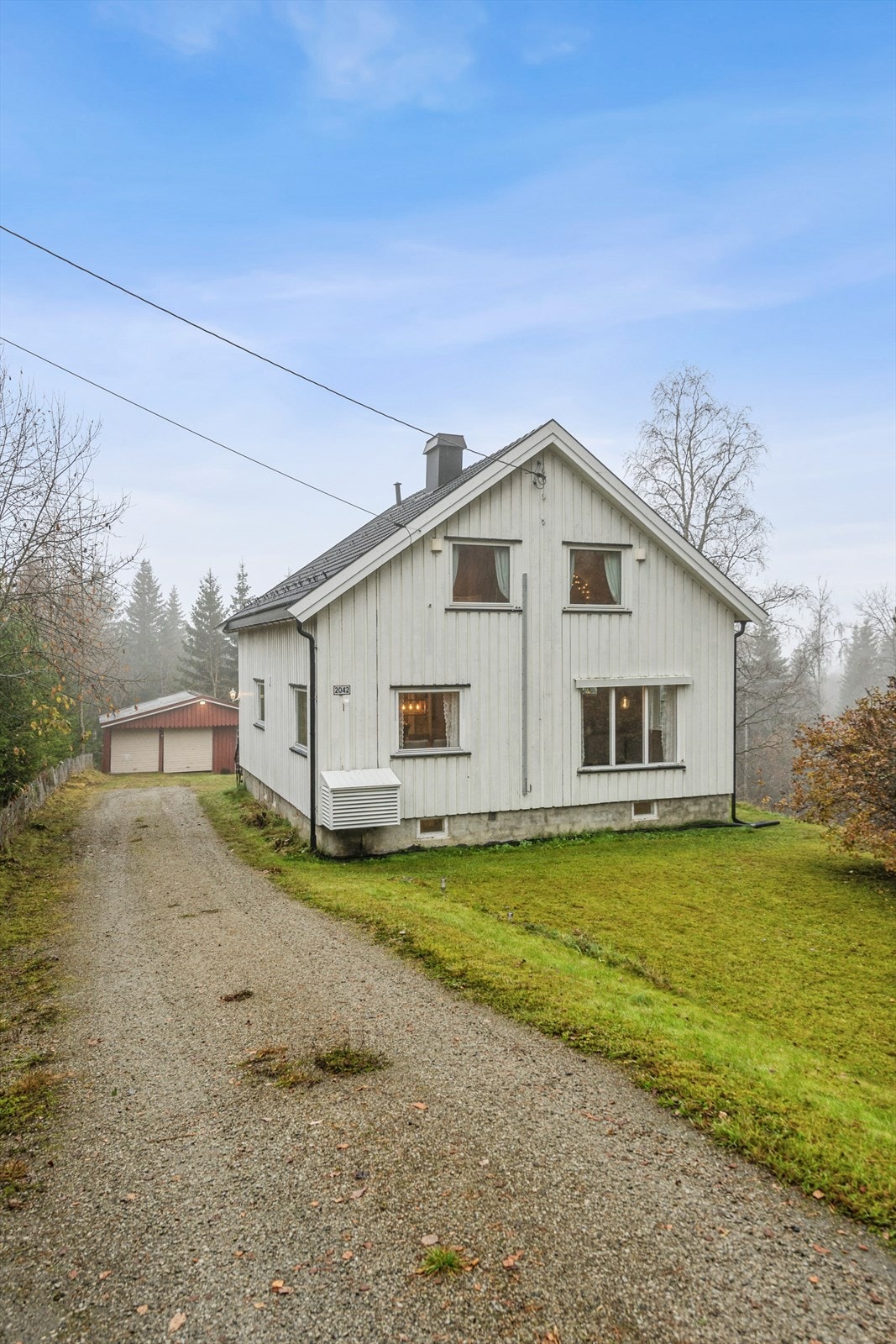 Eiendommen har en romslig gårdsplass med adkomst til en garasjen. Galleribilde