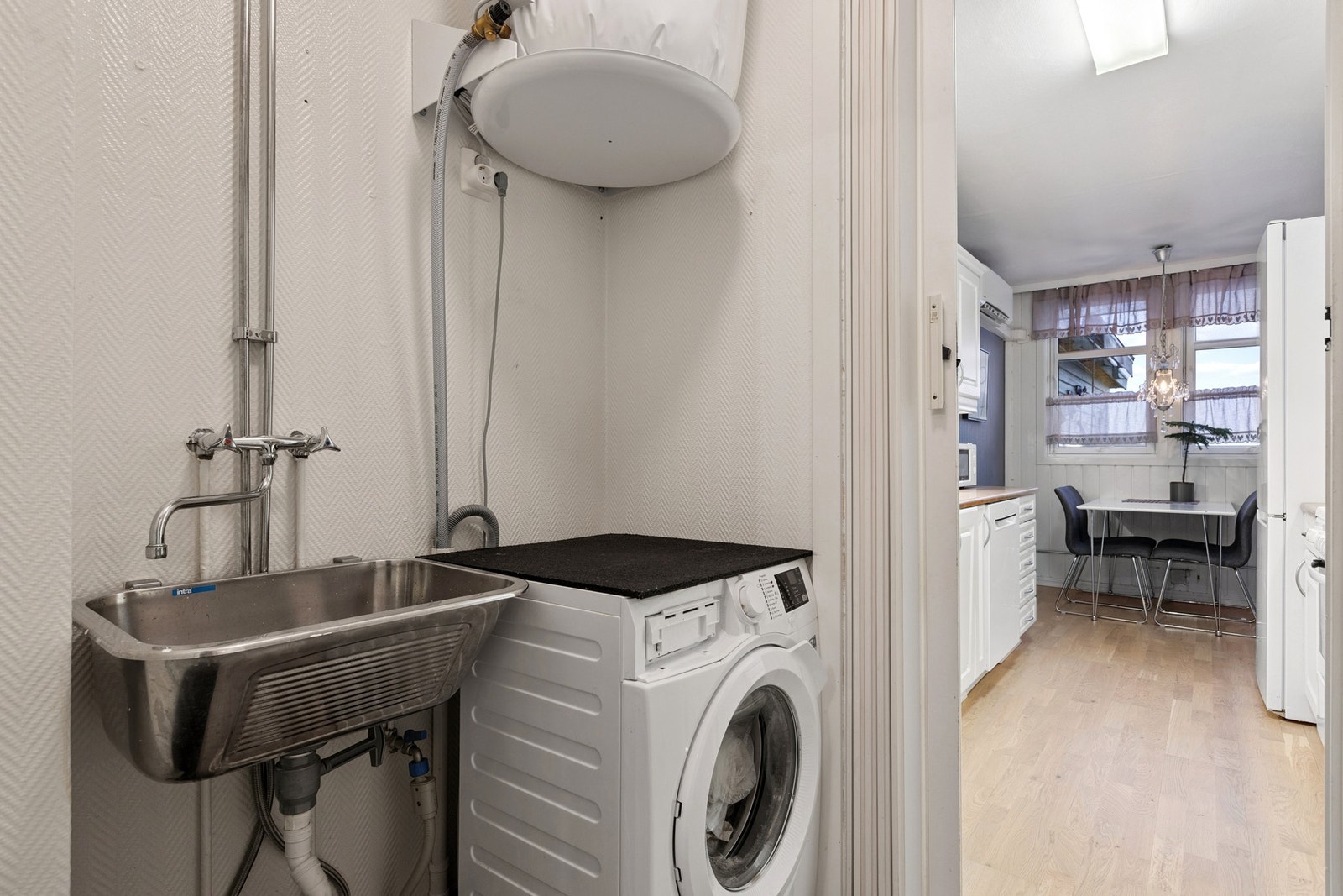 Praktisk vaskerom utstyrt med opplegg for vaskemaskin, bereder og skyllekum. Galleribilde