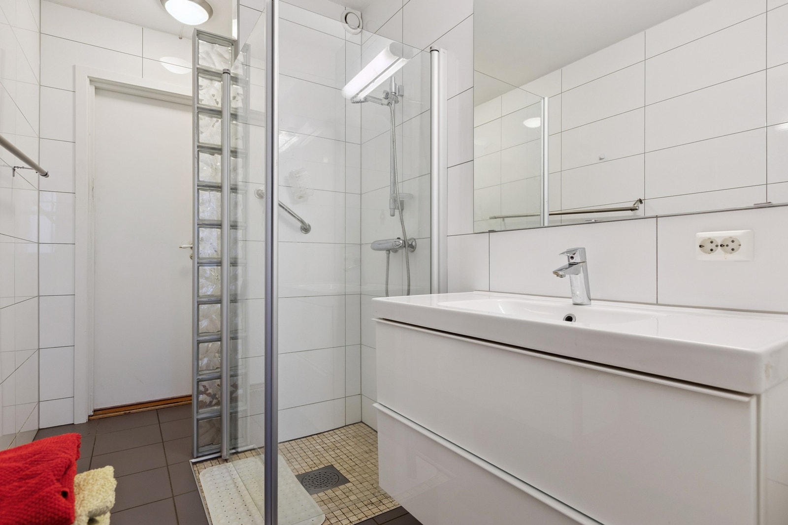 Badet er utstyrt med dusjnisje, mekanisk avtrekk, servant, servantskap og veggmontert wc. Galleribilde