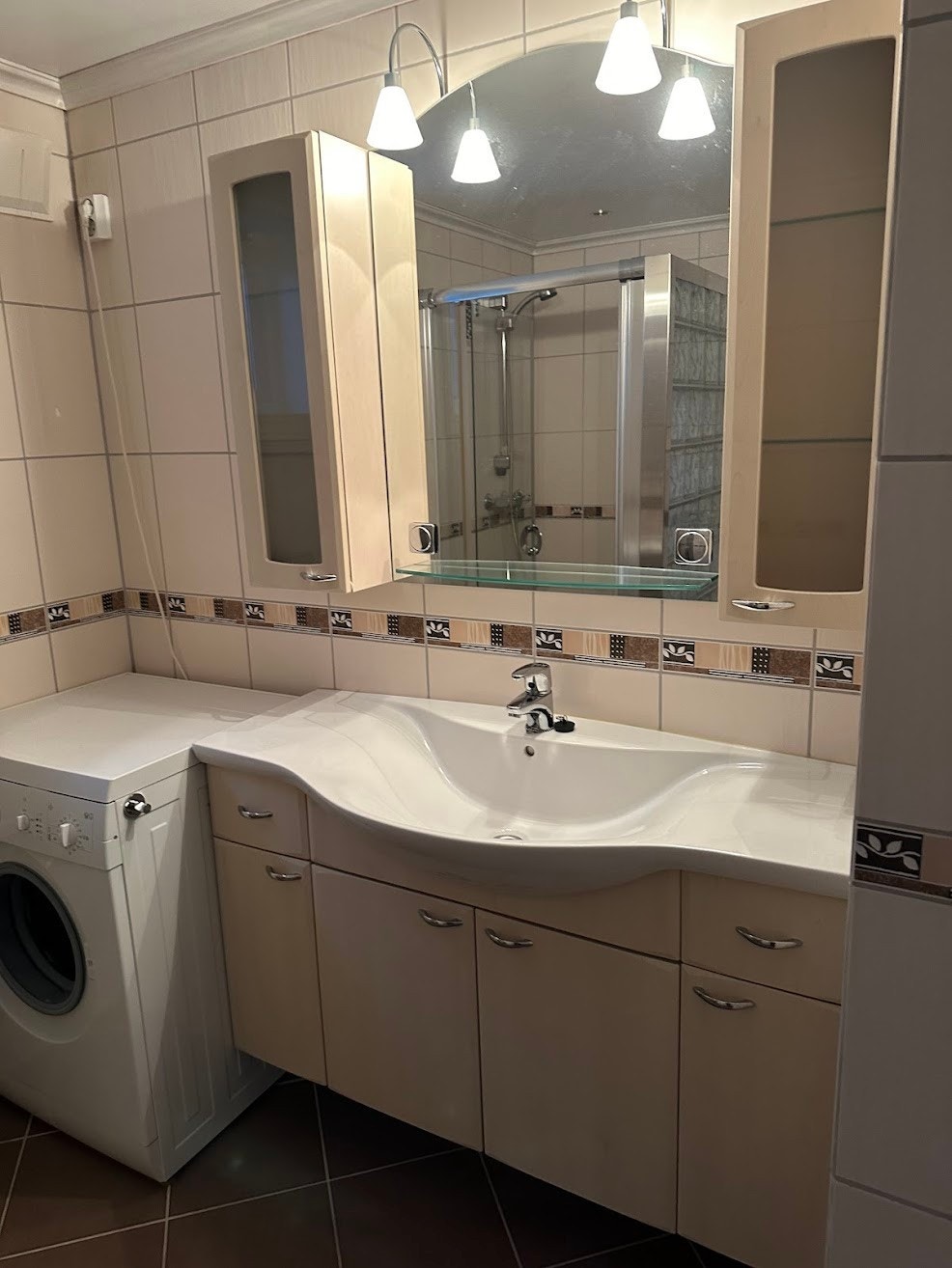 Badet har vaskemaskin, vegghengt wc, dusj, og mye skapplass i speilskap og servantskap Galleribilde