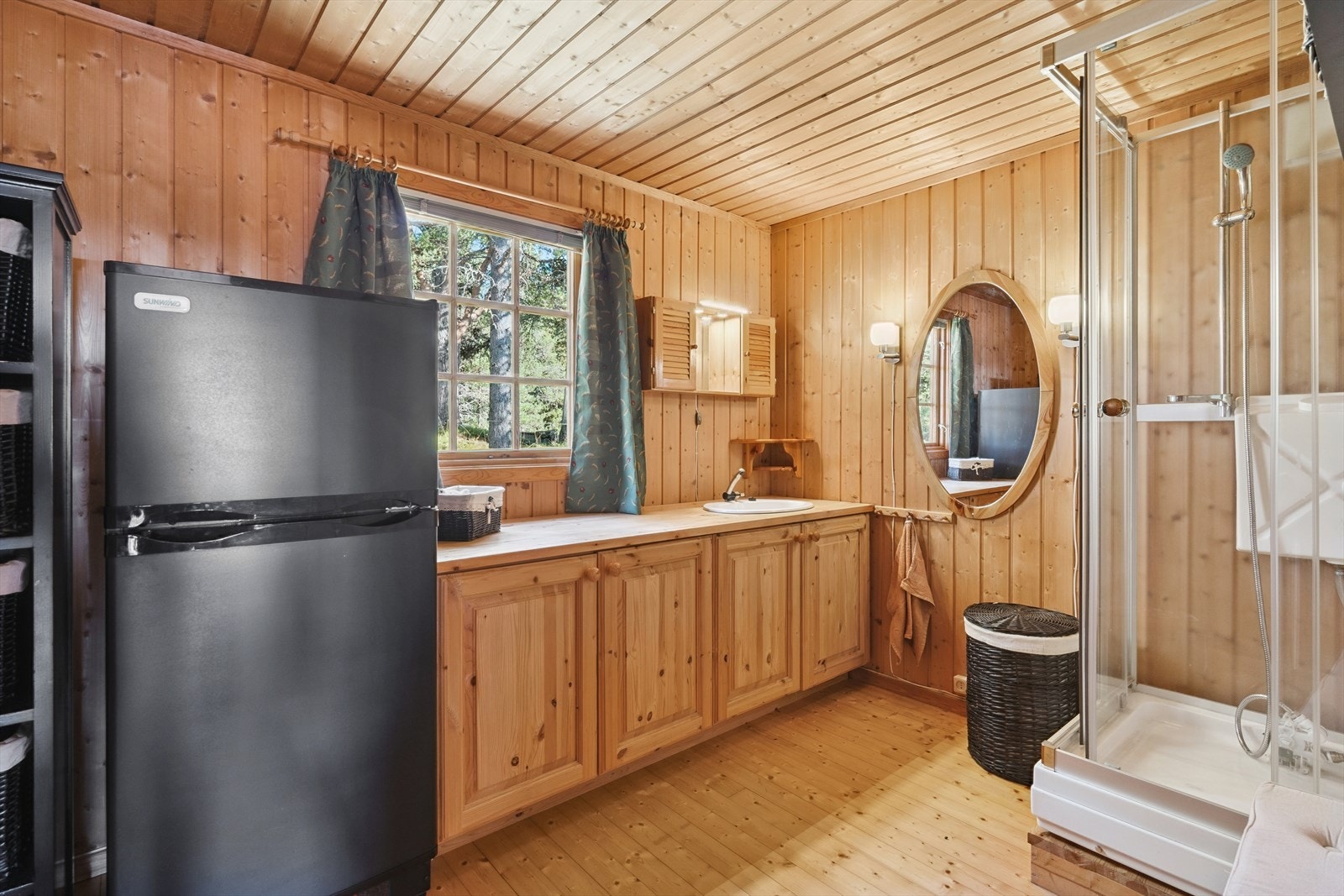 Hyttebad med servant og dusjkabinett, med vann fra beholder og tråpumpe. Galleribilde