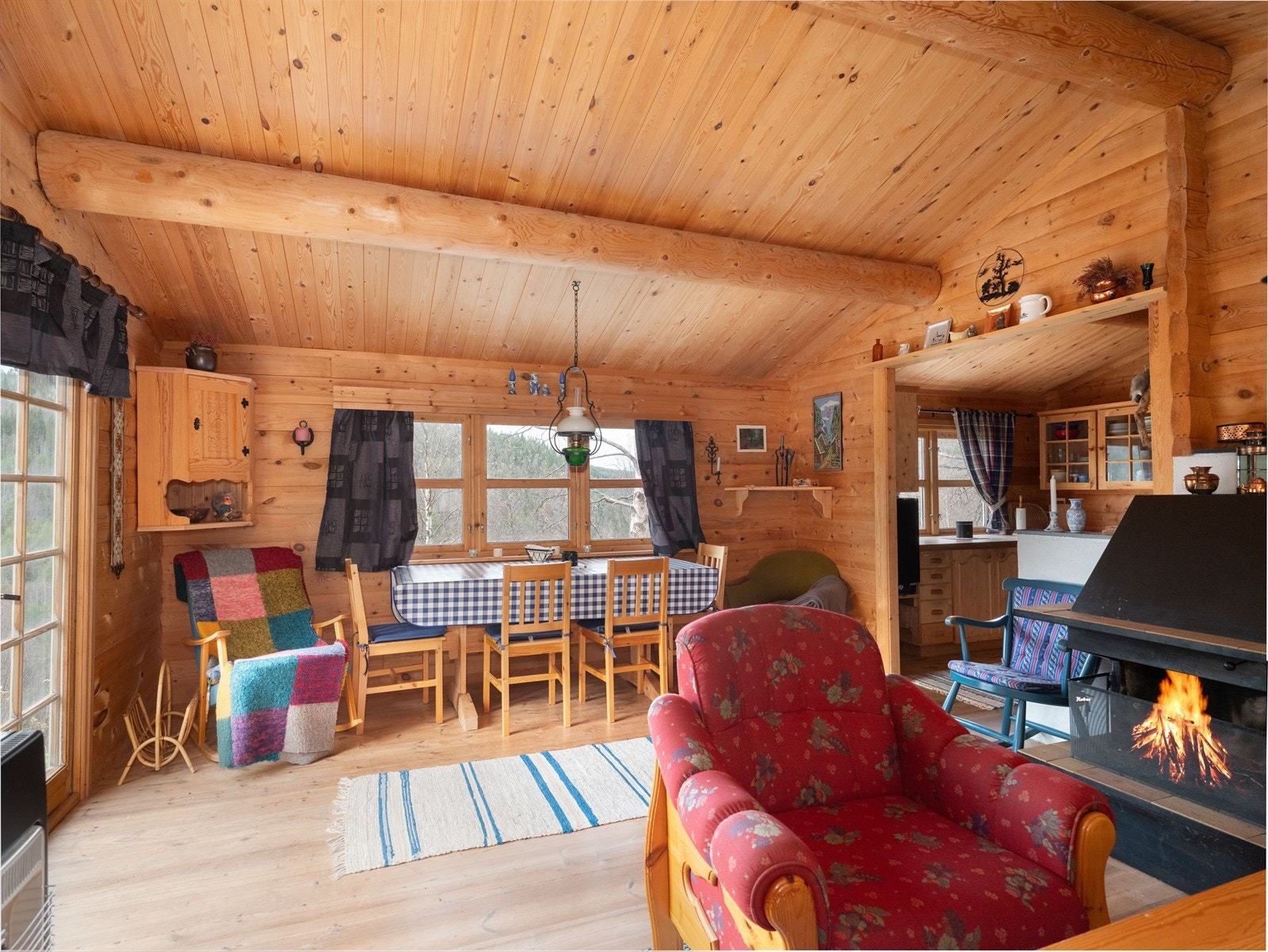 Lun og koselig stue med tømmervegger, store vinduer og god plass til familie og venner Galleribilde