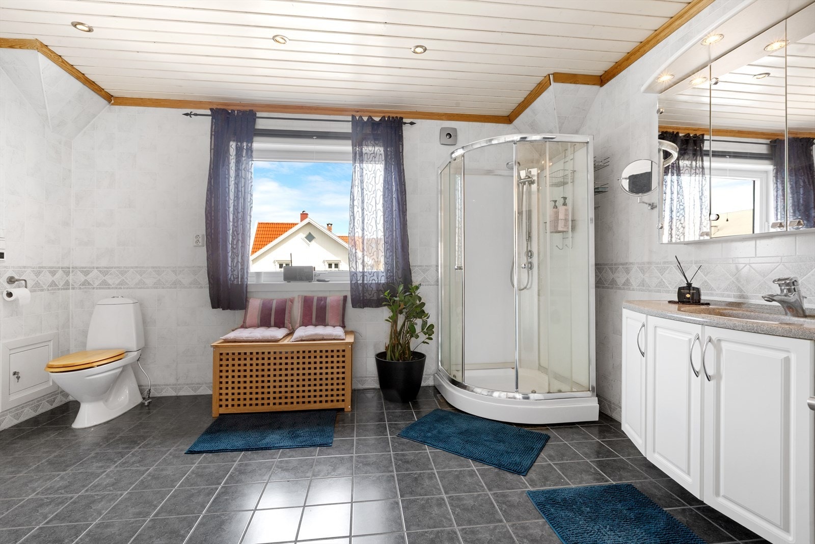 Romslig bad med dusjkabinett, wc, servantinnredning og varme i gulvet Galleribilde