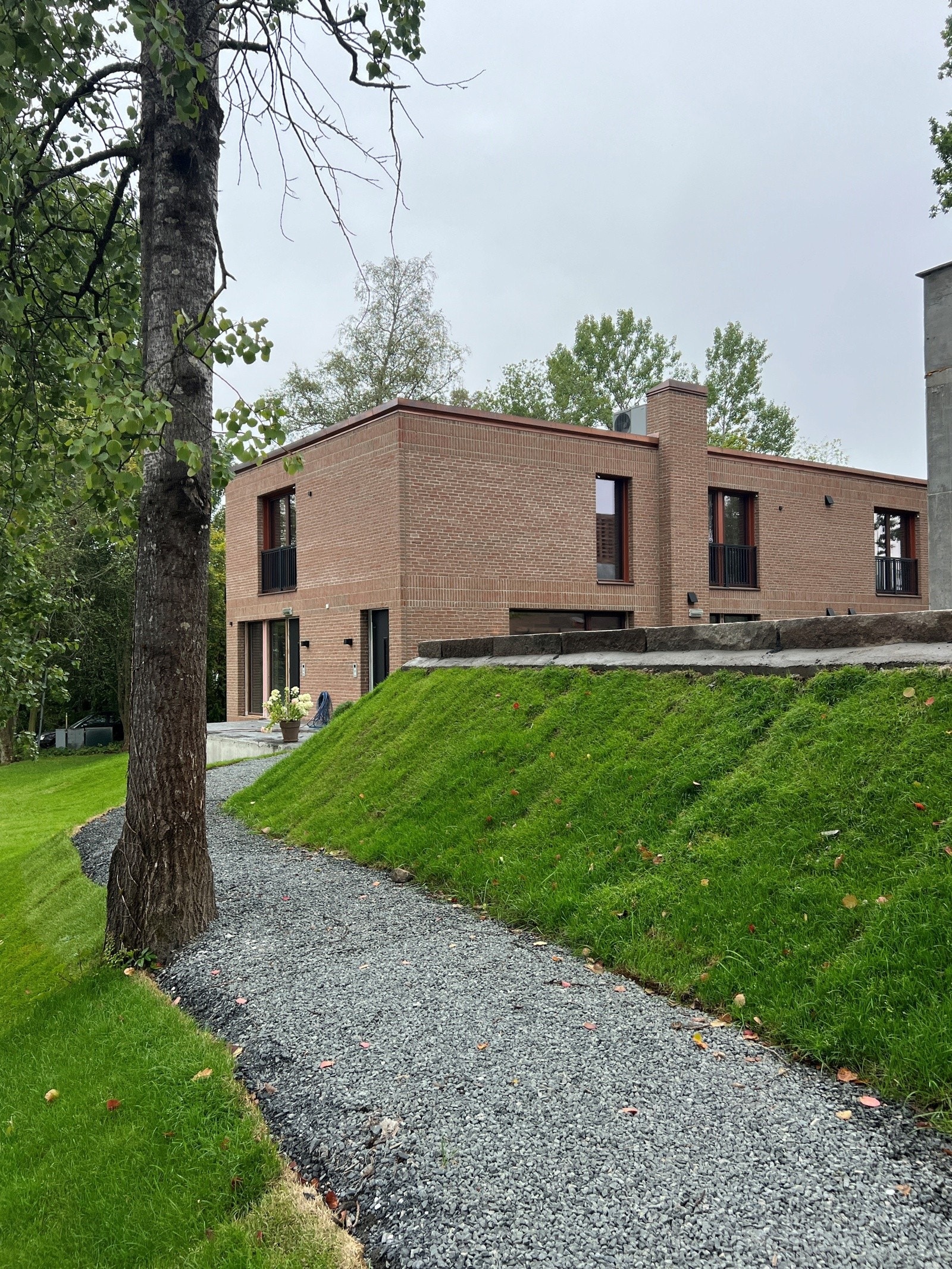 Gruset adkomststi til bygget, med belysning.