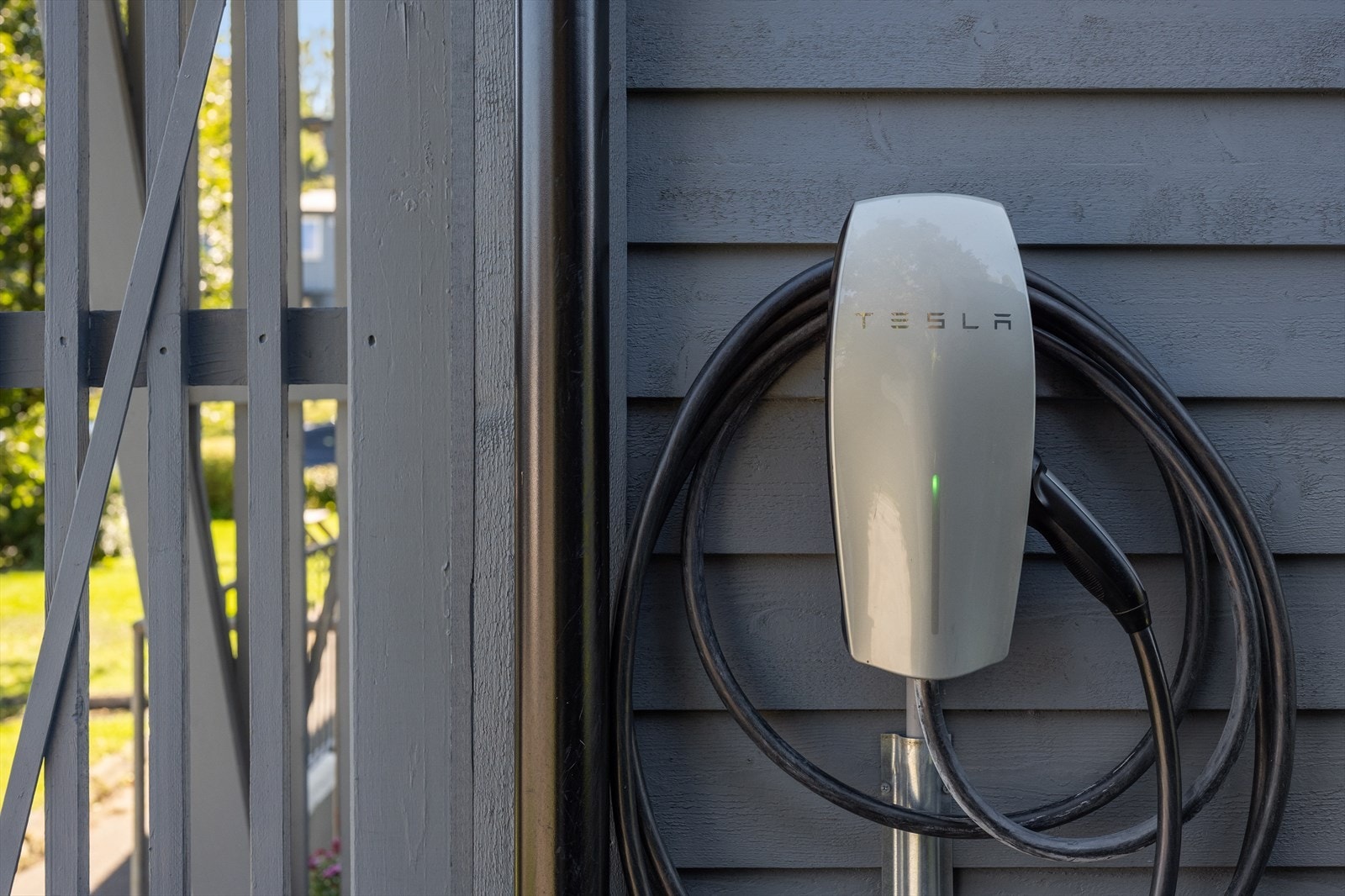 Det er montert elbillader på husveggen rundt hjørnet for inngangsdøren. Galleribilde