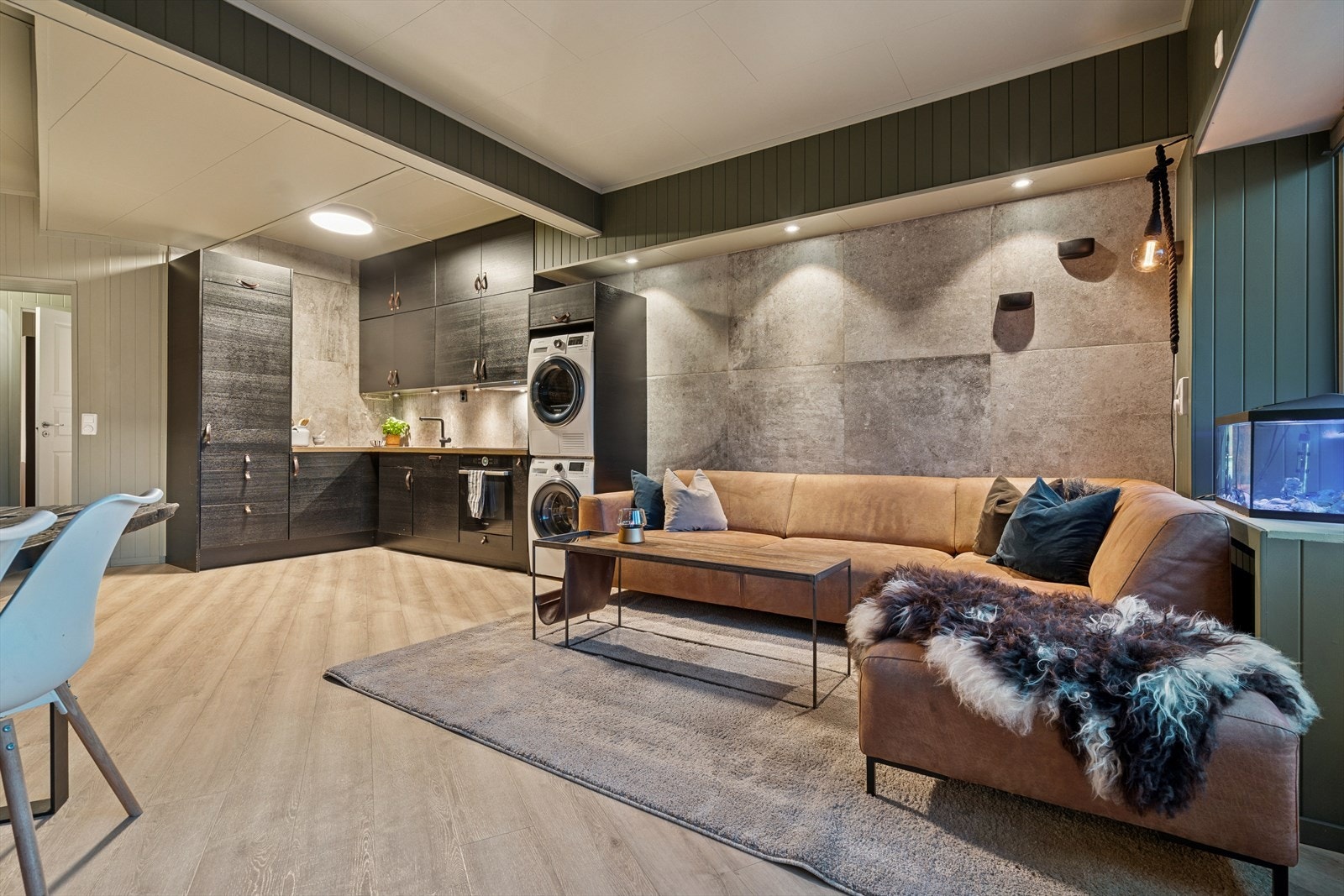 Stue og kjøkken ligger i moderne åpen løsning - Rommet et utført med et pent laminatgulv, vegger med panel malt i en tidsriktig farge og enkelte flislagte vegger Galleribilde