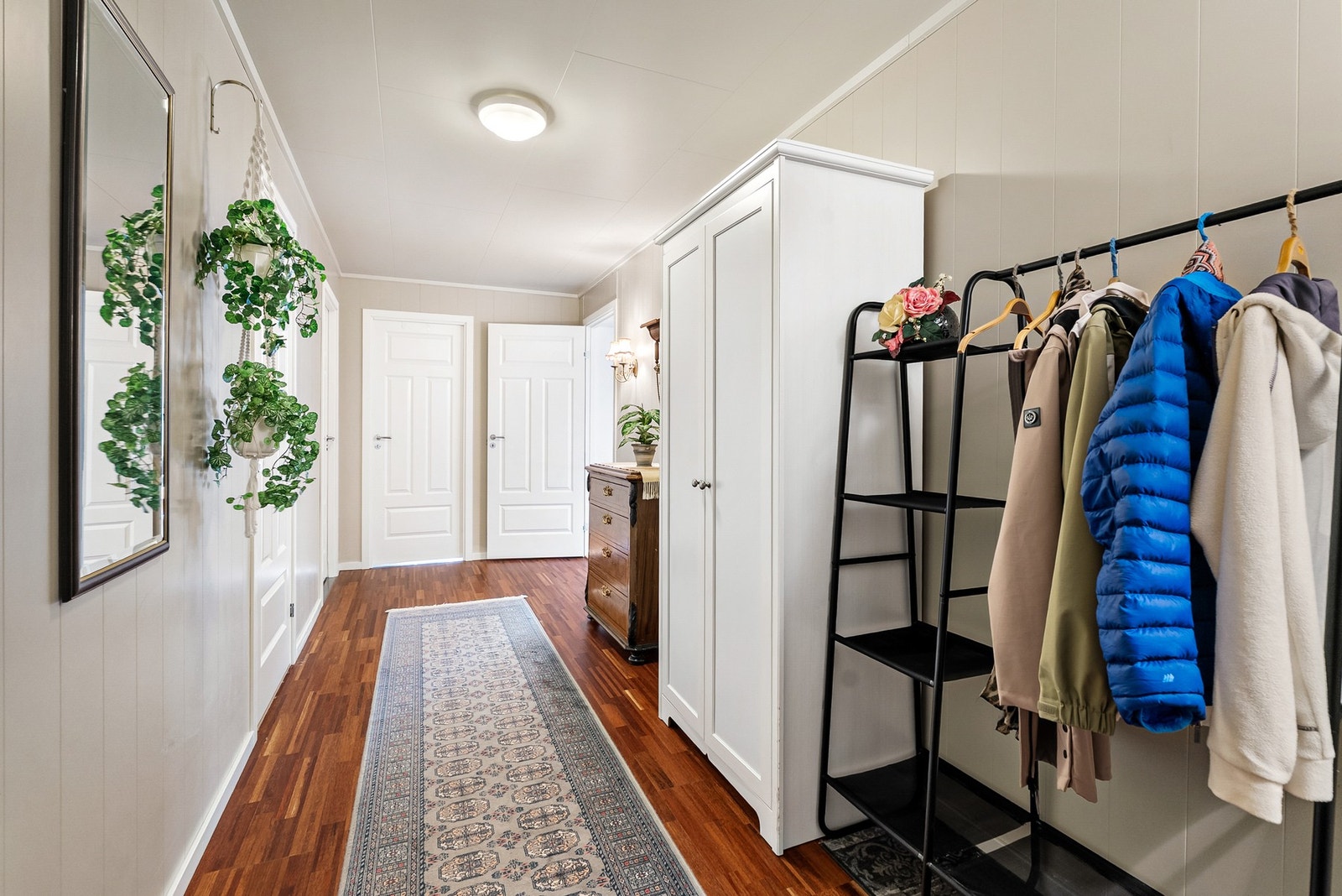 Velkommen inn til en romslig entré med tilhørende gang. Her er det god plass til ulike garderobeløsninger og praktisk oppheng for ytterklær. Galleribilde