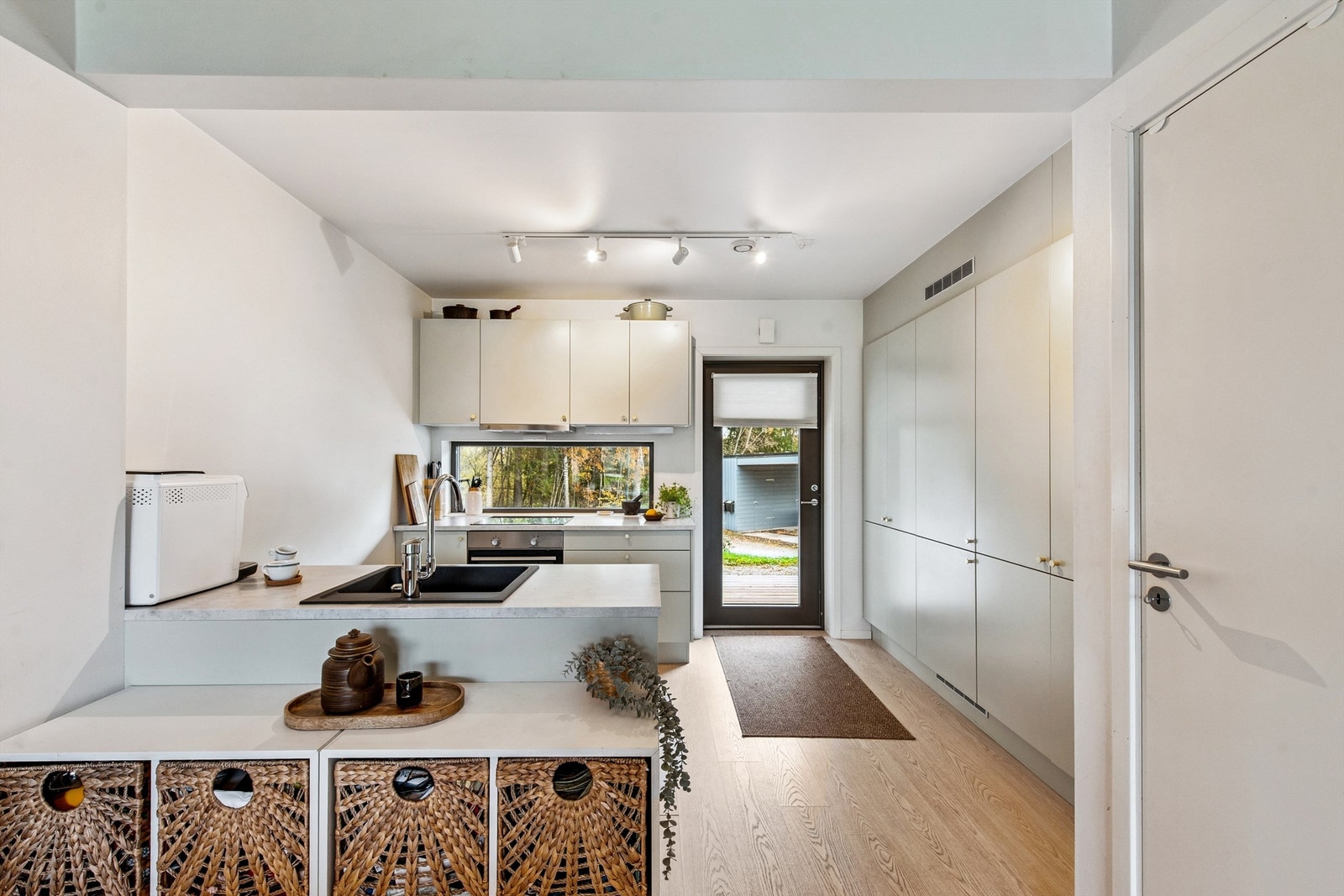 Vi starter i første etasje, som har en kombinert entré og kjøkken med varme i gulvet. Her er både garderobeskap, kjøl/frys og oppbevaring i høyskap. Galleribilde