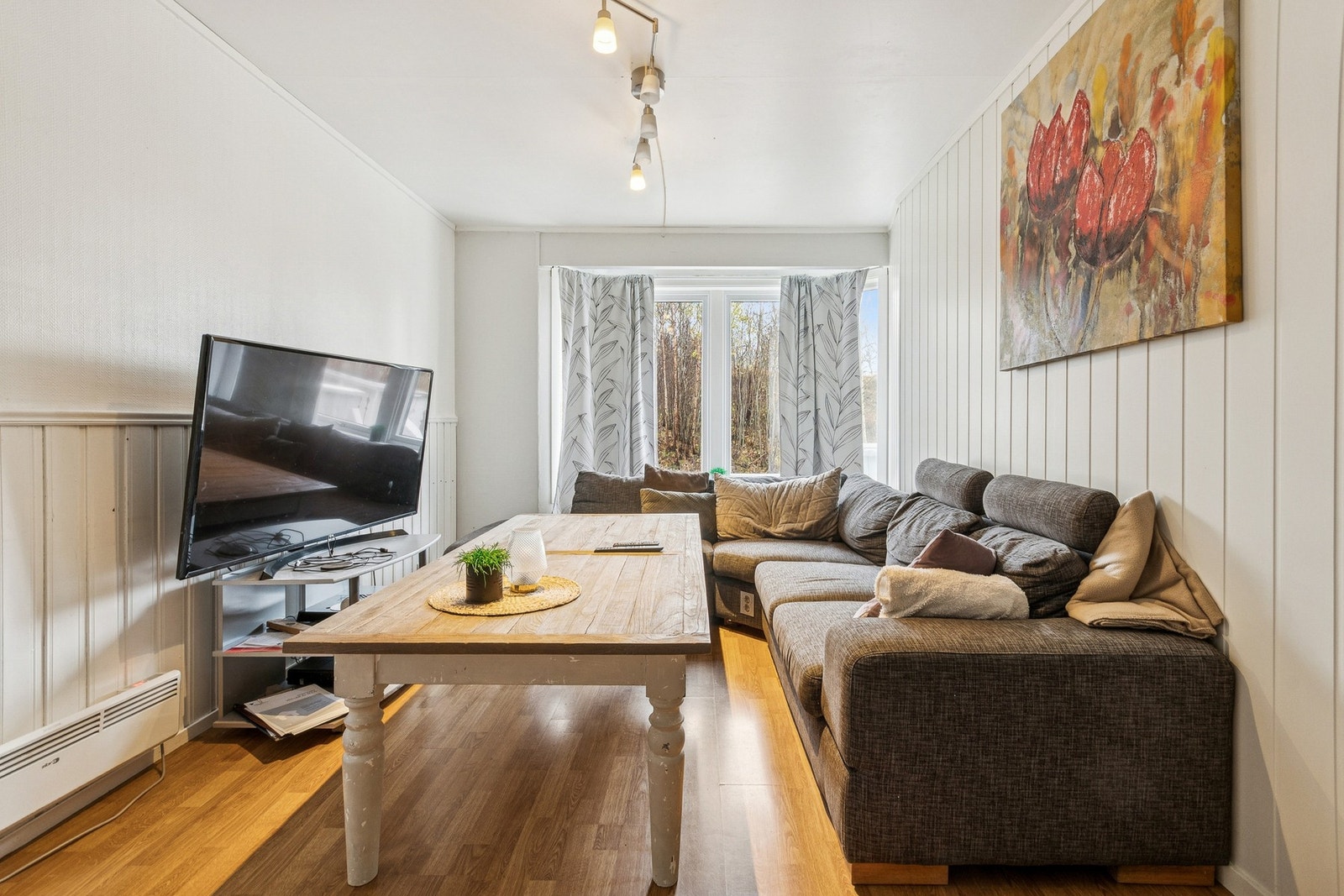 Det er en lukket stue/kjøkken løsning, der stua har plass til sittegruppe. Galleribilde