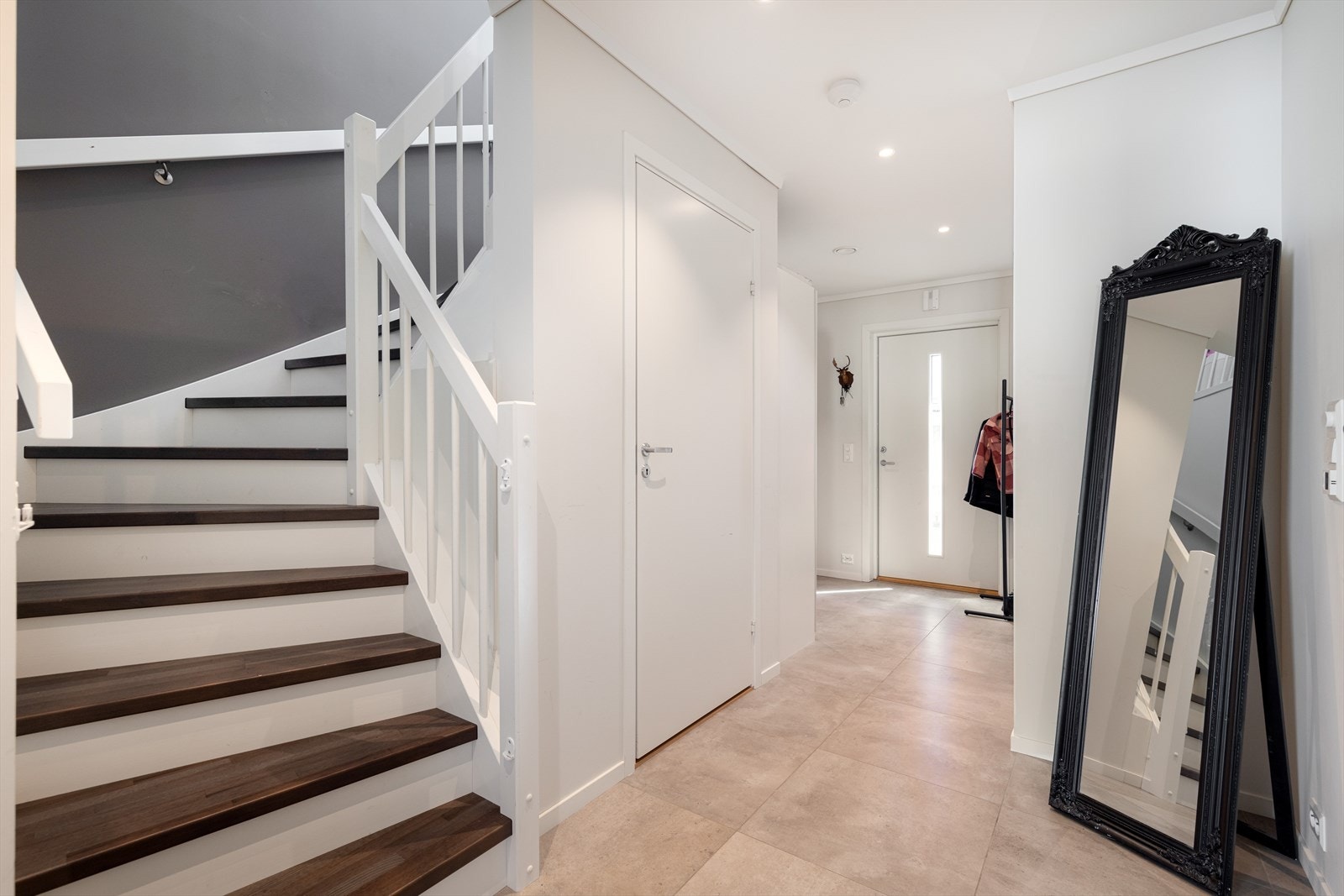 Romslig entre/trappegang med god plass til sko og yttertøy. Det er vannbåren varme i gulv. Galleribilde