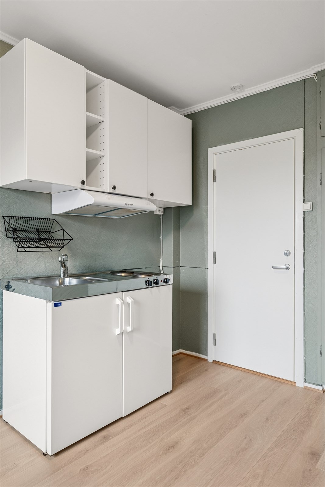 Hybelkjøkken med koketopp, kjøleskap og kjøkkenvifte. Galleribilde