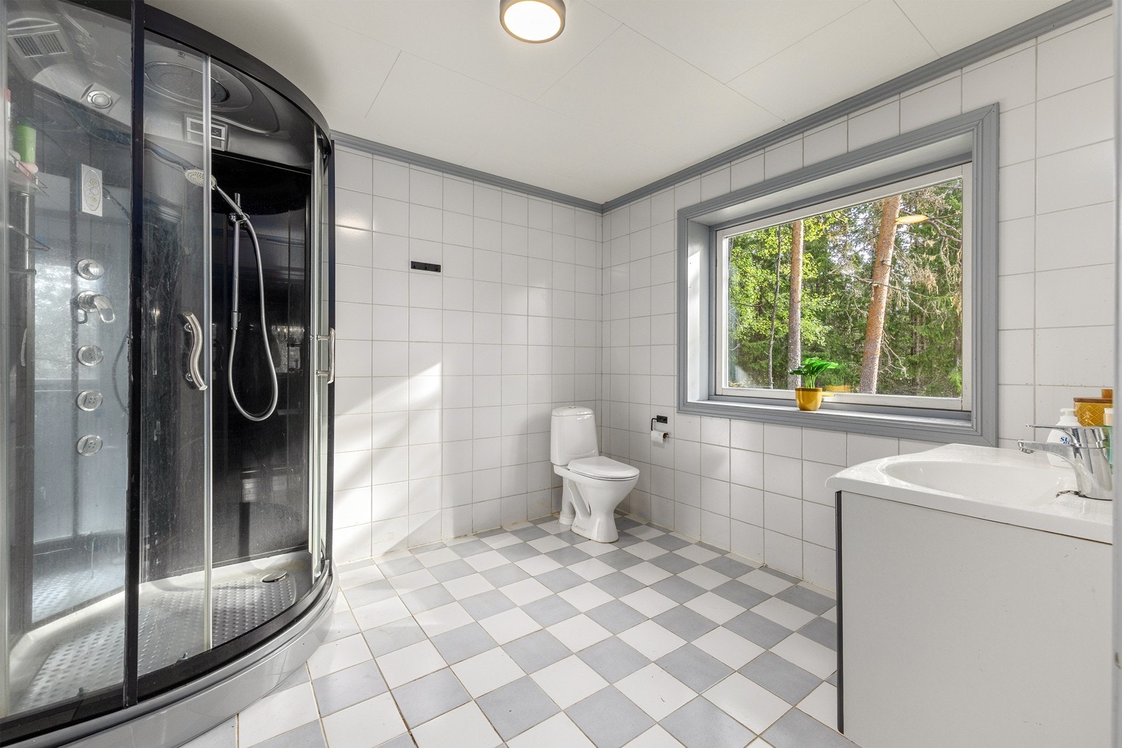 Bad med flislagte vegger og gulv. Varmekabler i gulv. Badet er utstyrt med dusjkabinett, wc og servant Galleribilde