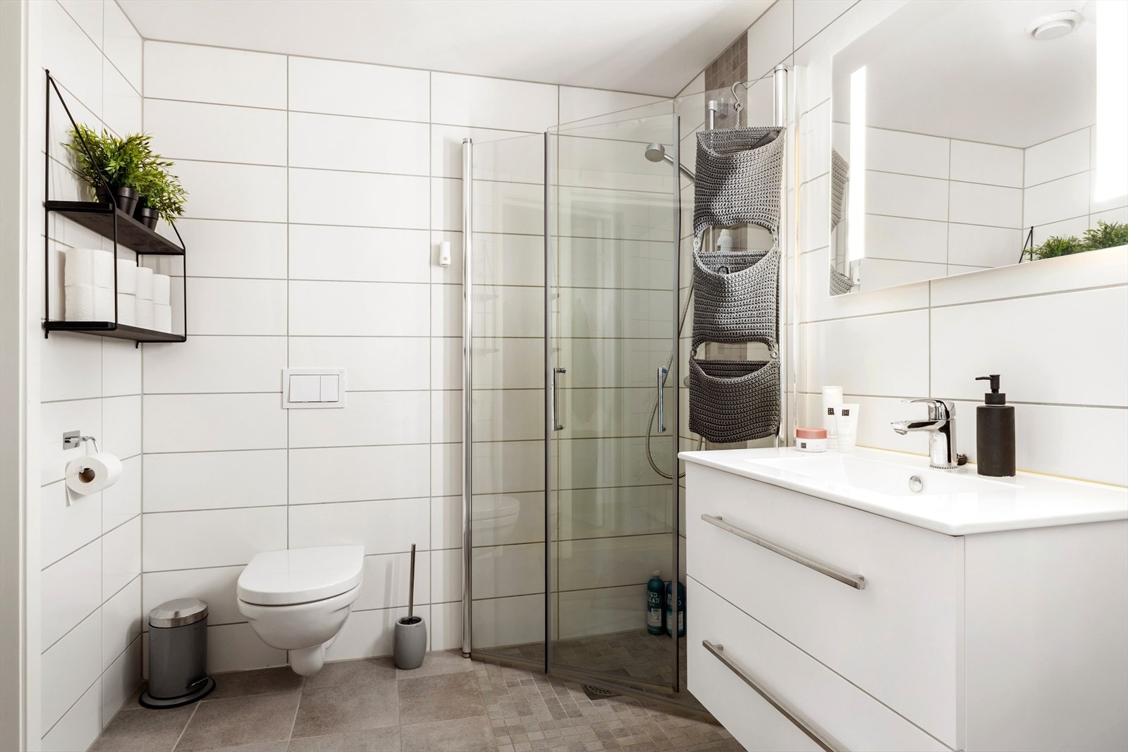 Lekkert bad med lyse overflater og innadslående dusjdører for optimal plassutnyttelse. Galleribilde