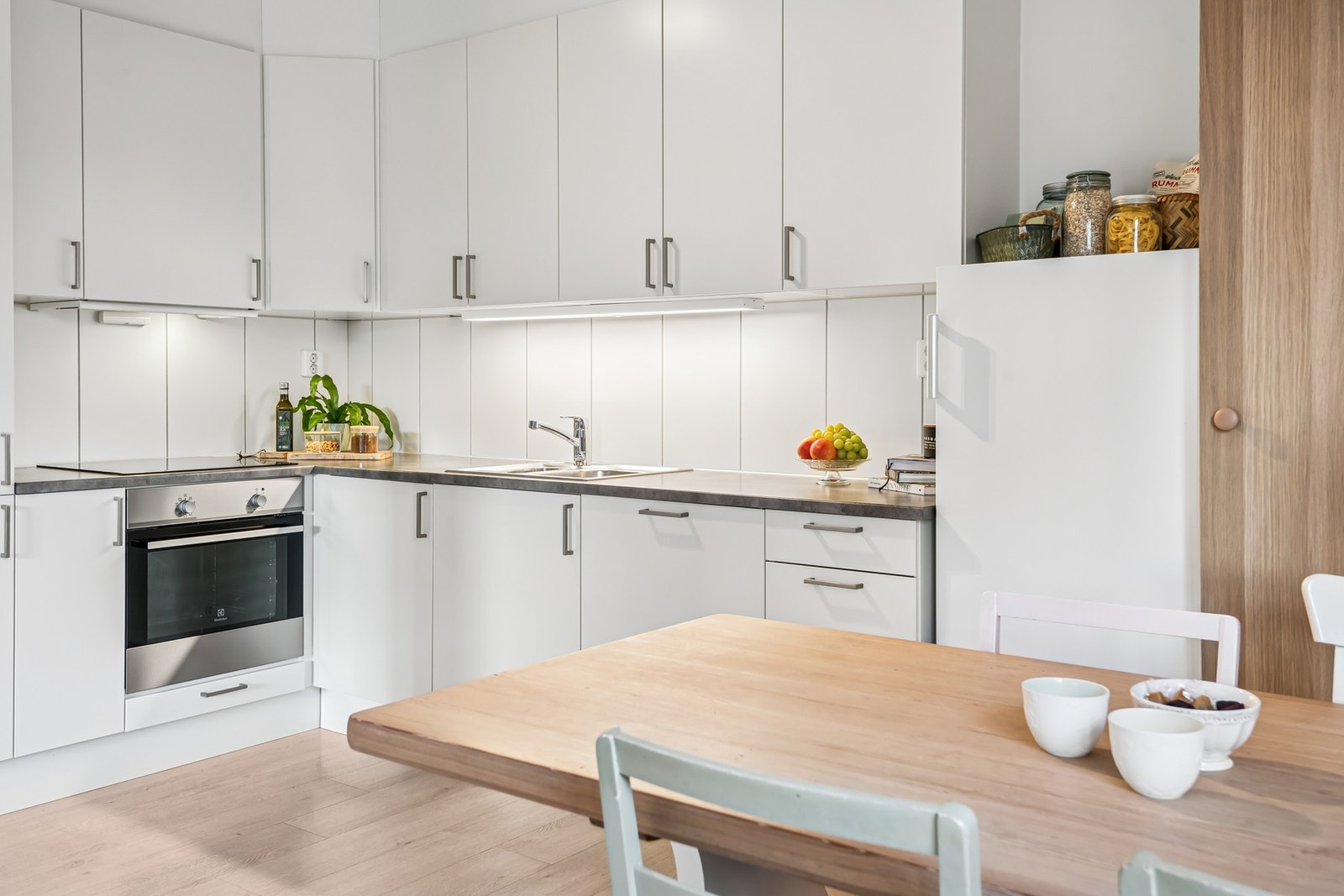 Kjøkkenet er utstyrt med integrerte hvitevarer, herunder keramisk koketopp, stekeovn, oppvaskmaskin og kjøleskap med frysedel. Galleribilde