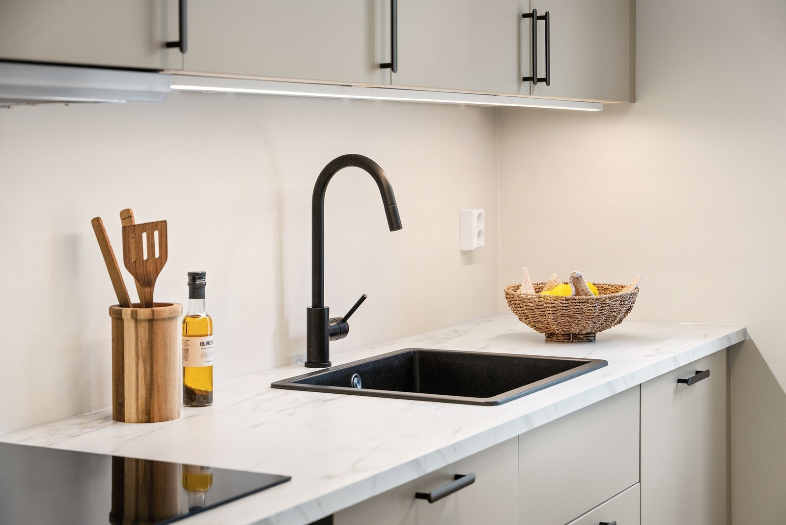 Kjøkkenet har beige fronter, laminat benkeplate og detaljer i sort, noe som gir et stilfullt uttrykk. Galleribilde