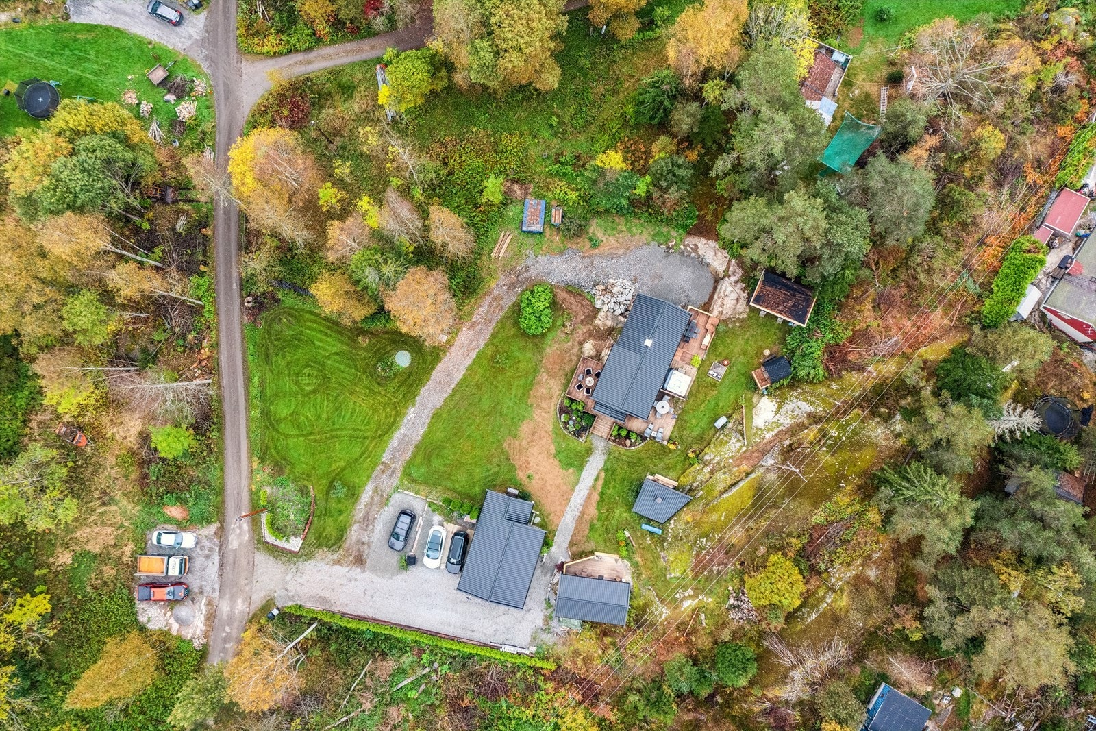 Eiendommen sett ovenfra. Begge tomter mellom grusvei følger. Galleribilde