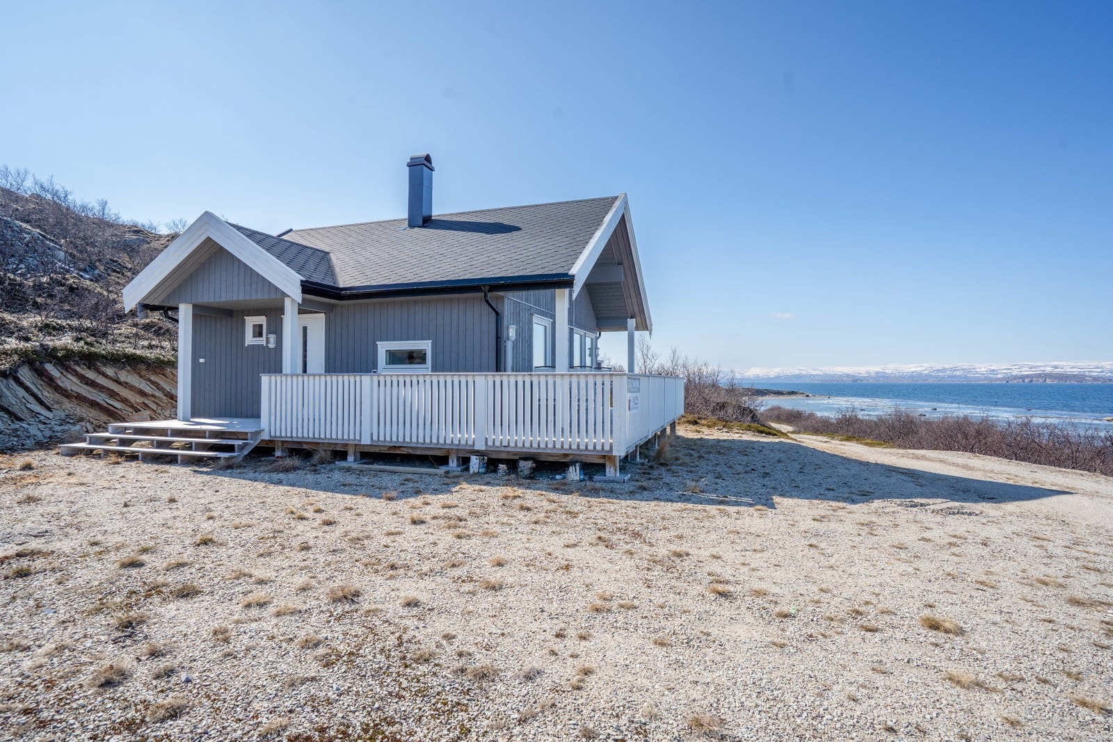 Fasade med biloppstillingsplass som er gruslagt Galleribilde