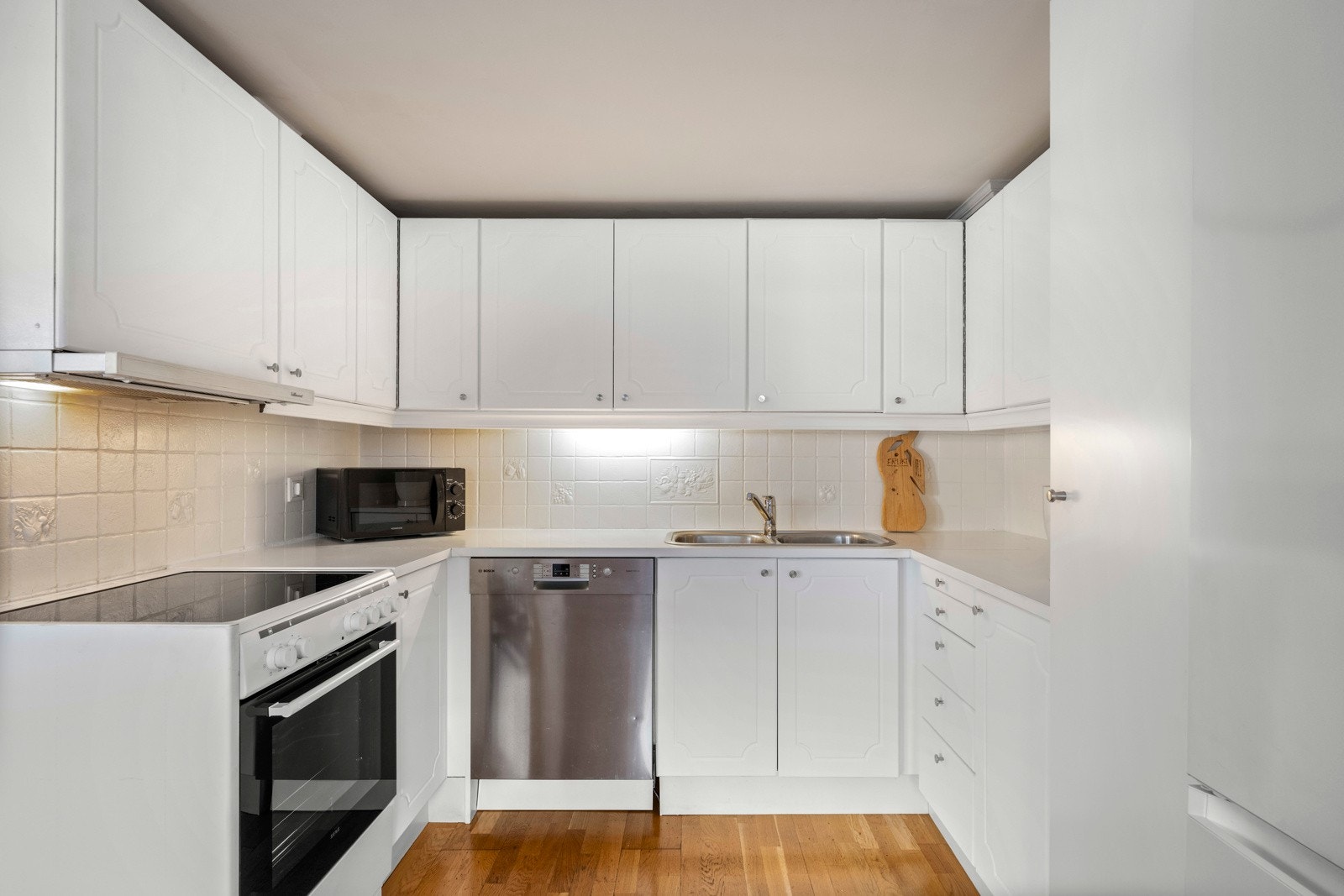 Kjøkken med profilerte fronter og en åpen planløsning mot spisestuen, perfekt for sosialt samvær. Galleribilde