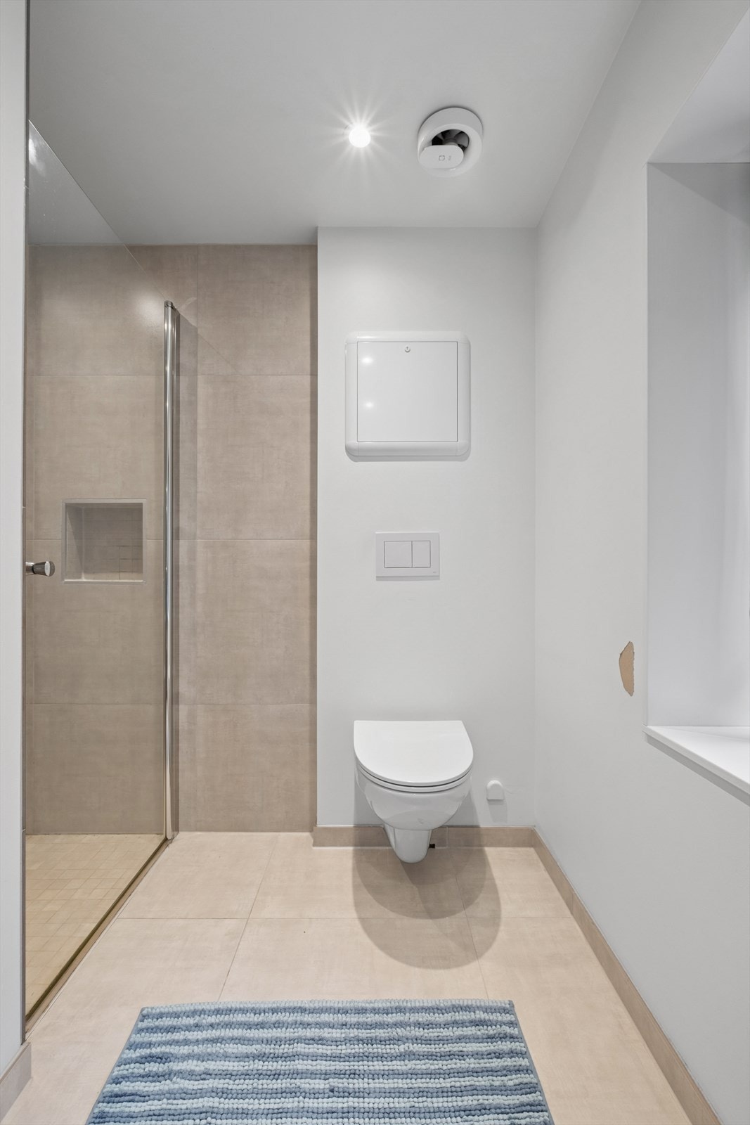 Badet er ellers utstyrt med benkeplate med servant og veggmontert toalett. Galleribilde