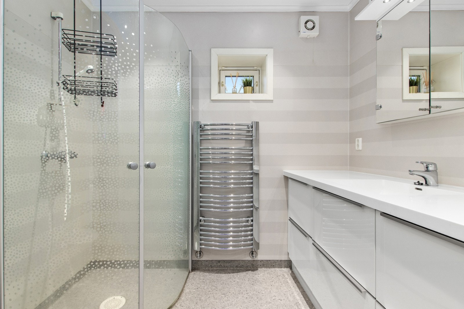 Lekkert, flislagt bad i hovedetasjen med dusj, servant med skuffer, speilskap og toalett. Galleribilde