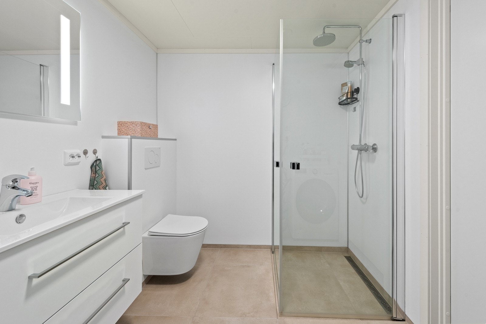 Pent flislagt bad med behagelige varmekabler i gulv samt opplegg for både vaskemaskin og tørketrommel Galleribilde