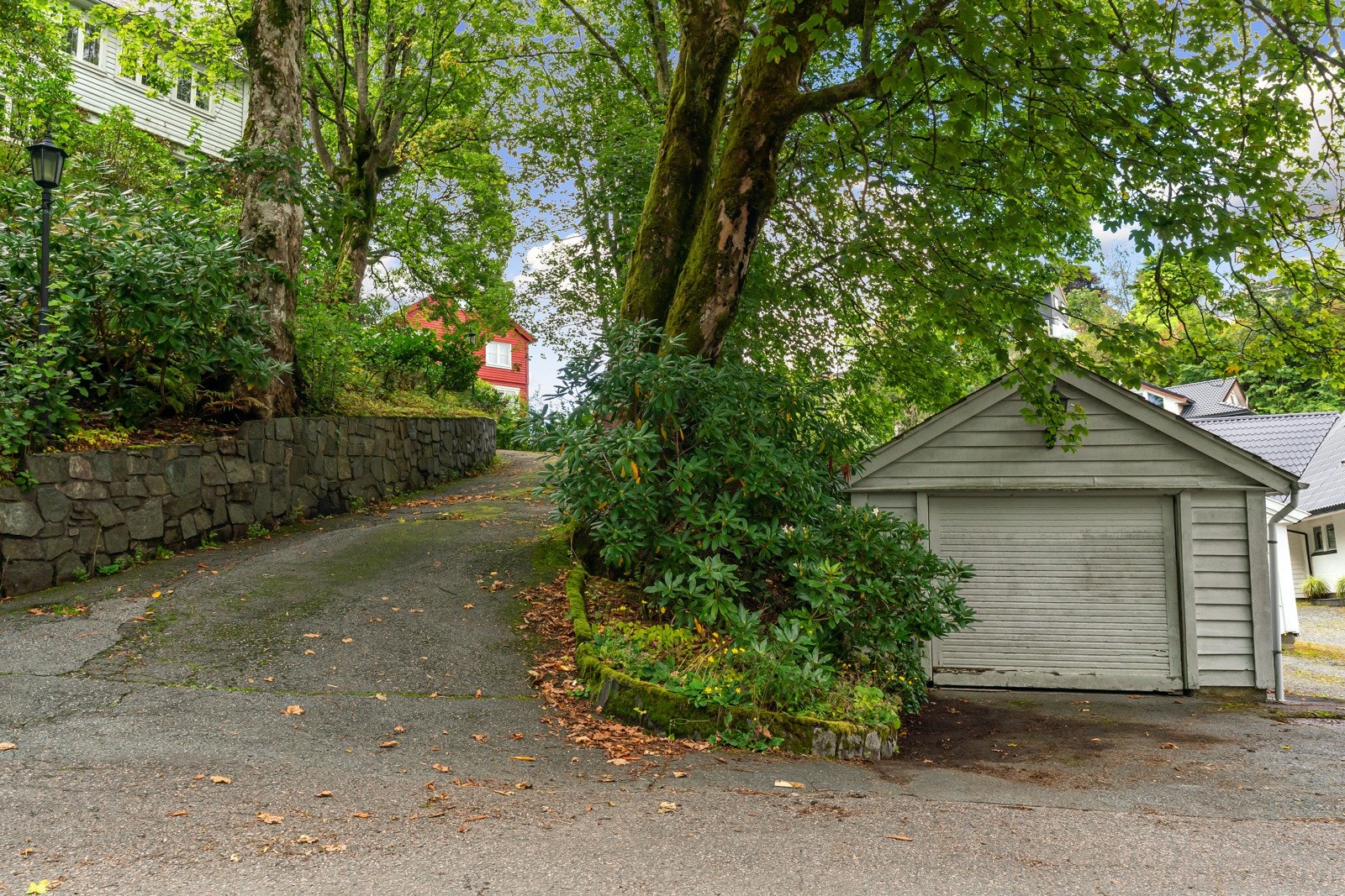 Det medfølger en frittliggende og eldre garasje på nedsiden av eiendommen (garasjen ligger på eget bruksnummer). Det er også mulig å parkere en bil i forkant av garasjen. Galleribilde