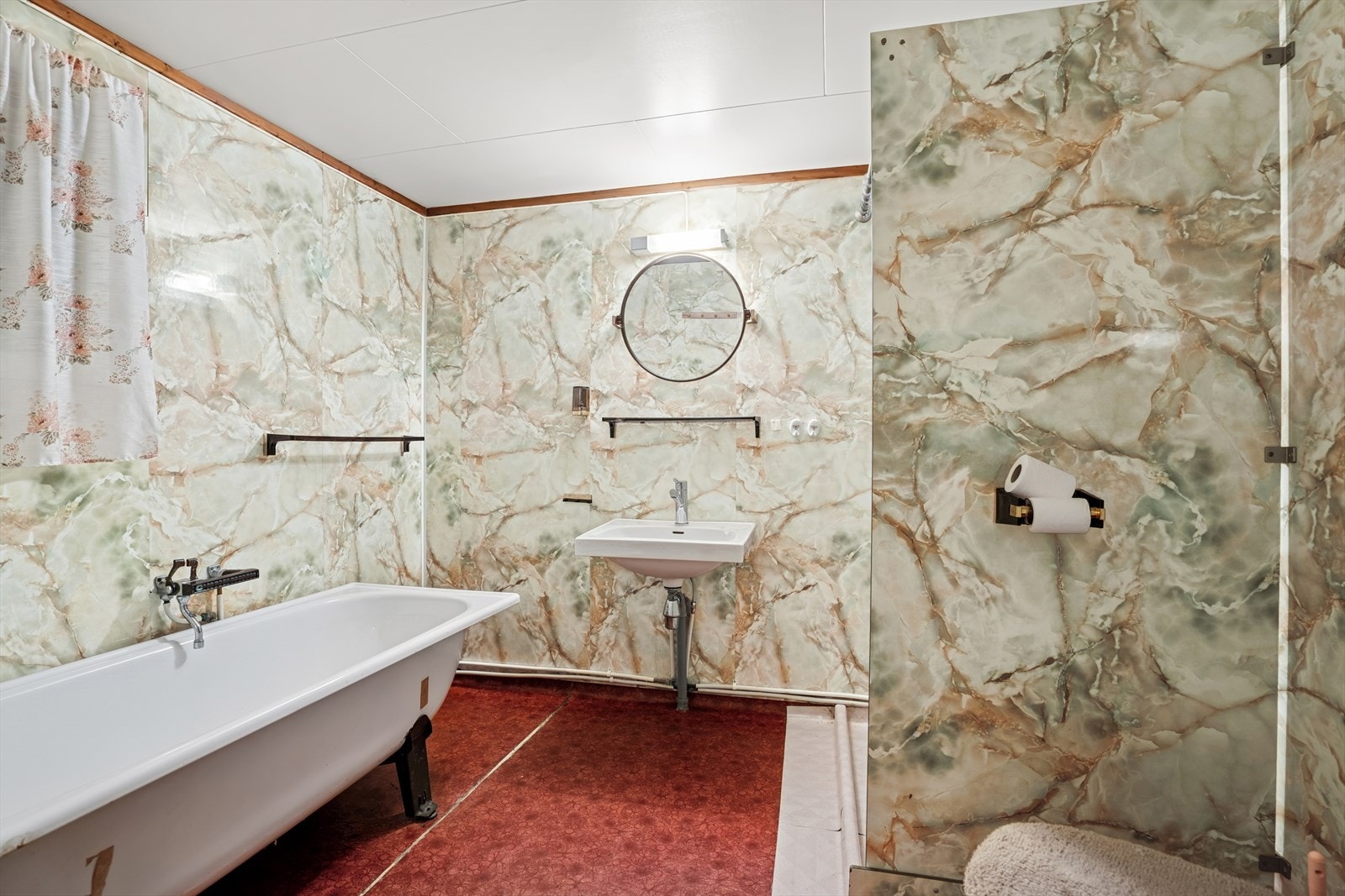 Badet i kjelleren er fra opprinnelig byggeår og fremstår med eldre løsninger og materialbruk. Det er registrert skader på belegg og membran, og våtrommet tilfredsstiller ikke dagens krav til tetthet i våtsone. Det er derfor gitt TG 3. Galleribilde