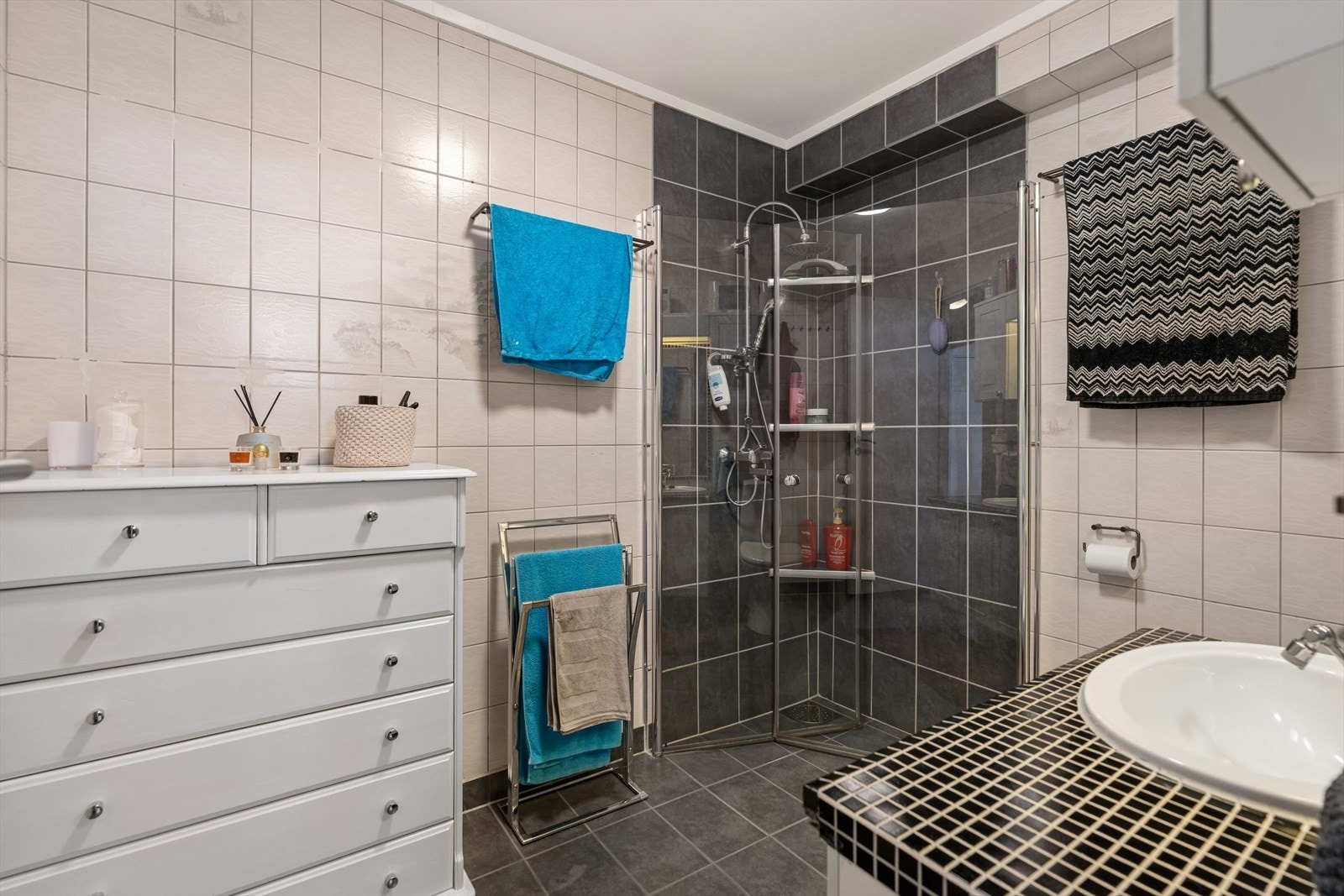 Badet er ellers utstyrt med dusjhjørne, toalett og veggseksjon med servant. Galleribilde