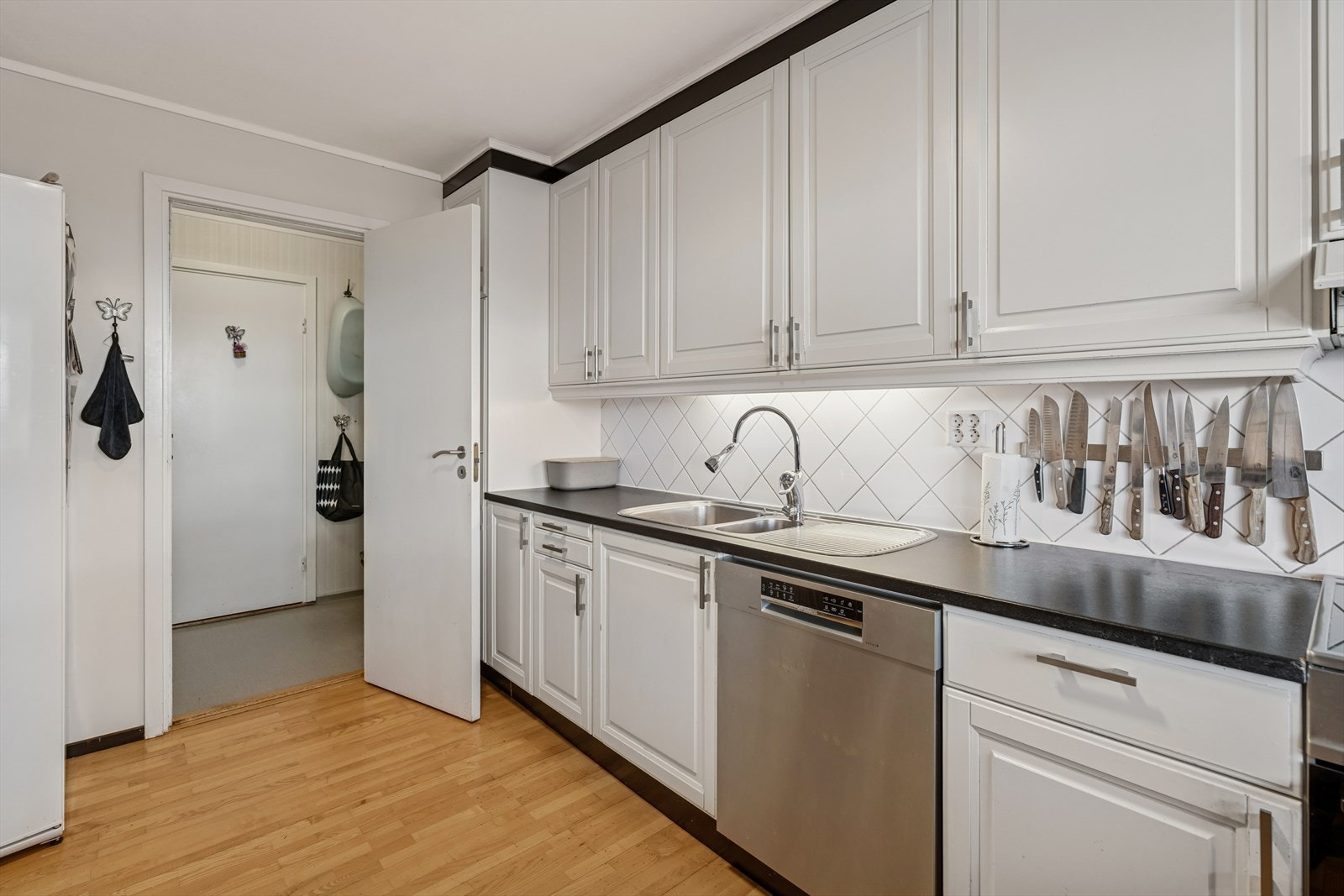 Kjøkkenet er ellers utstyrt med frittstående kjøleskap, oppvaskmaskin, komfyr og kjøkkenventilator med avtrekk ut. Galleribilde