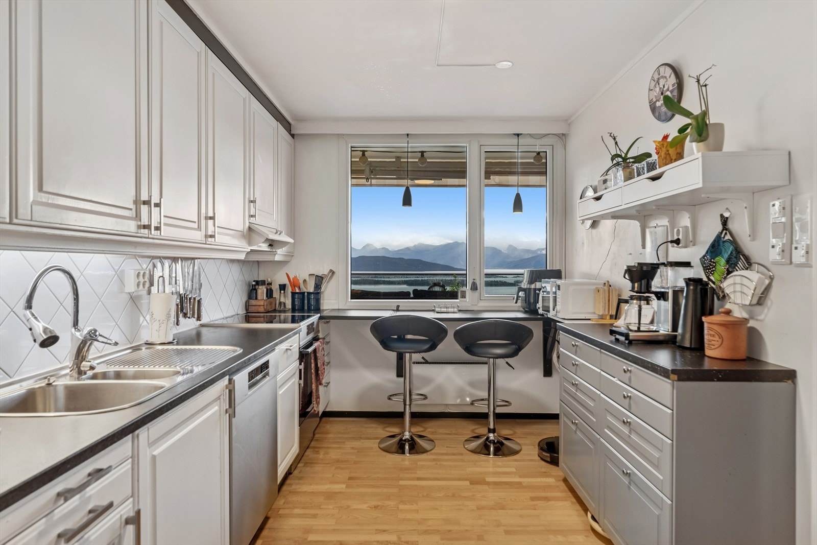 Kjøkkenet er tidløst innredet med en kombinasjon av hvite og grå, profilerte fronter og grå benkeplate i laminat. Et stort og godt kjøkken hvor man har godt med skap- og skuffeplass, samt gode arbeidsflater på benk. Galleribilde