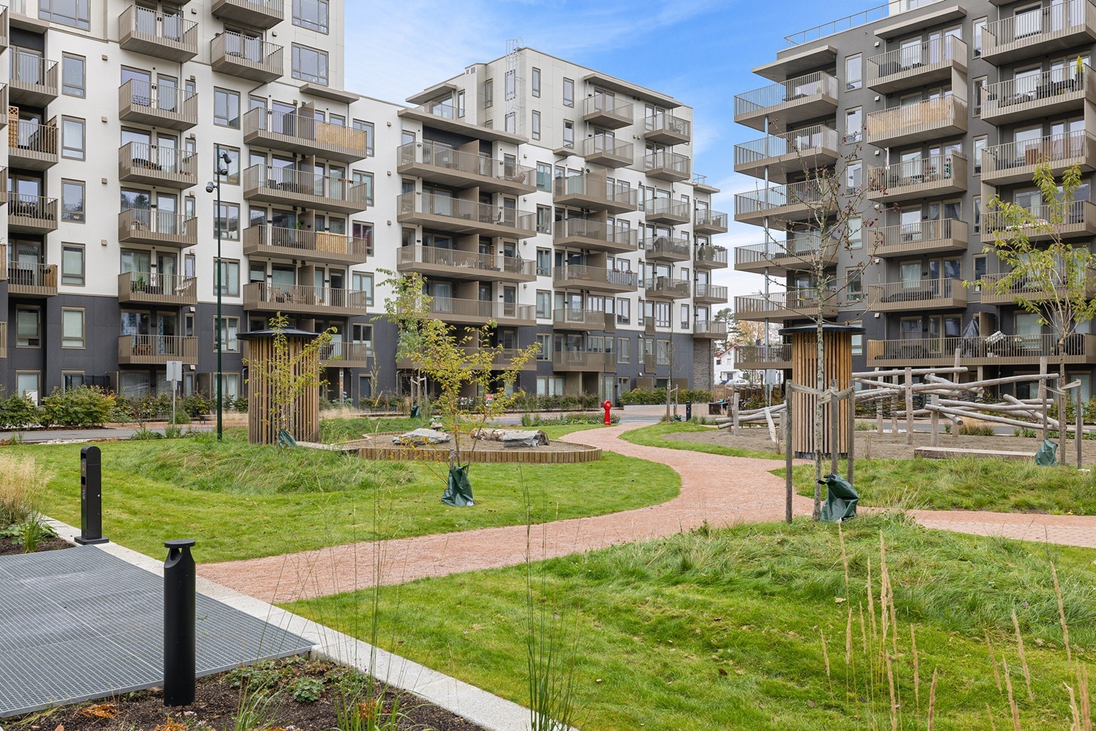 Sameiets tomt er flott opparbeidet med grønne plener, beplantning, gangstier og sosiale soner. Galleribilde