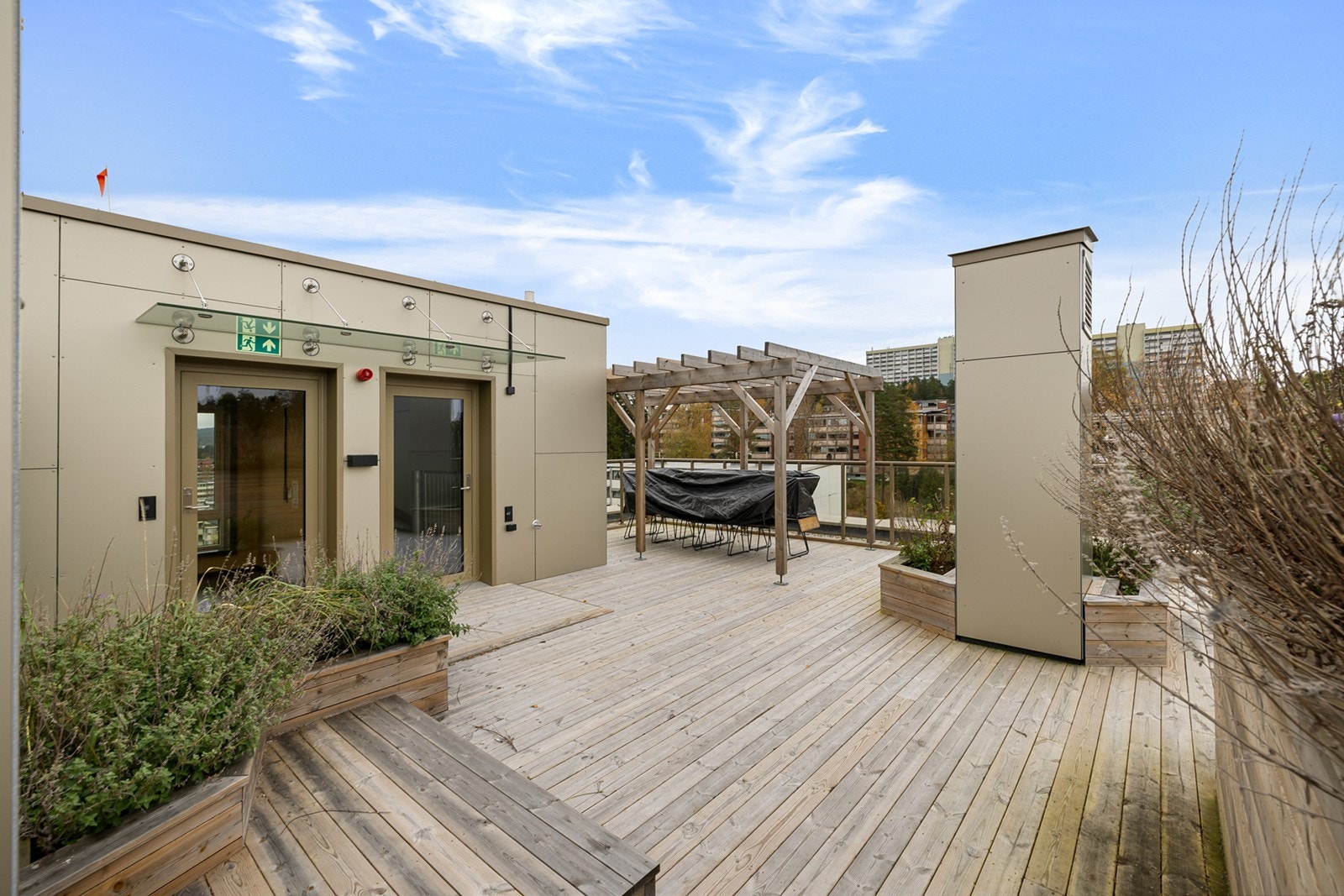 Terrassen er pent opparbeidet med tregulv, plantekasser og sittegrupper. Galleribilde