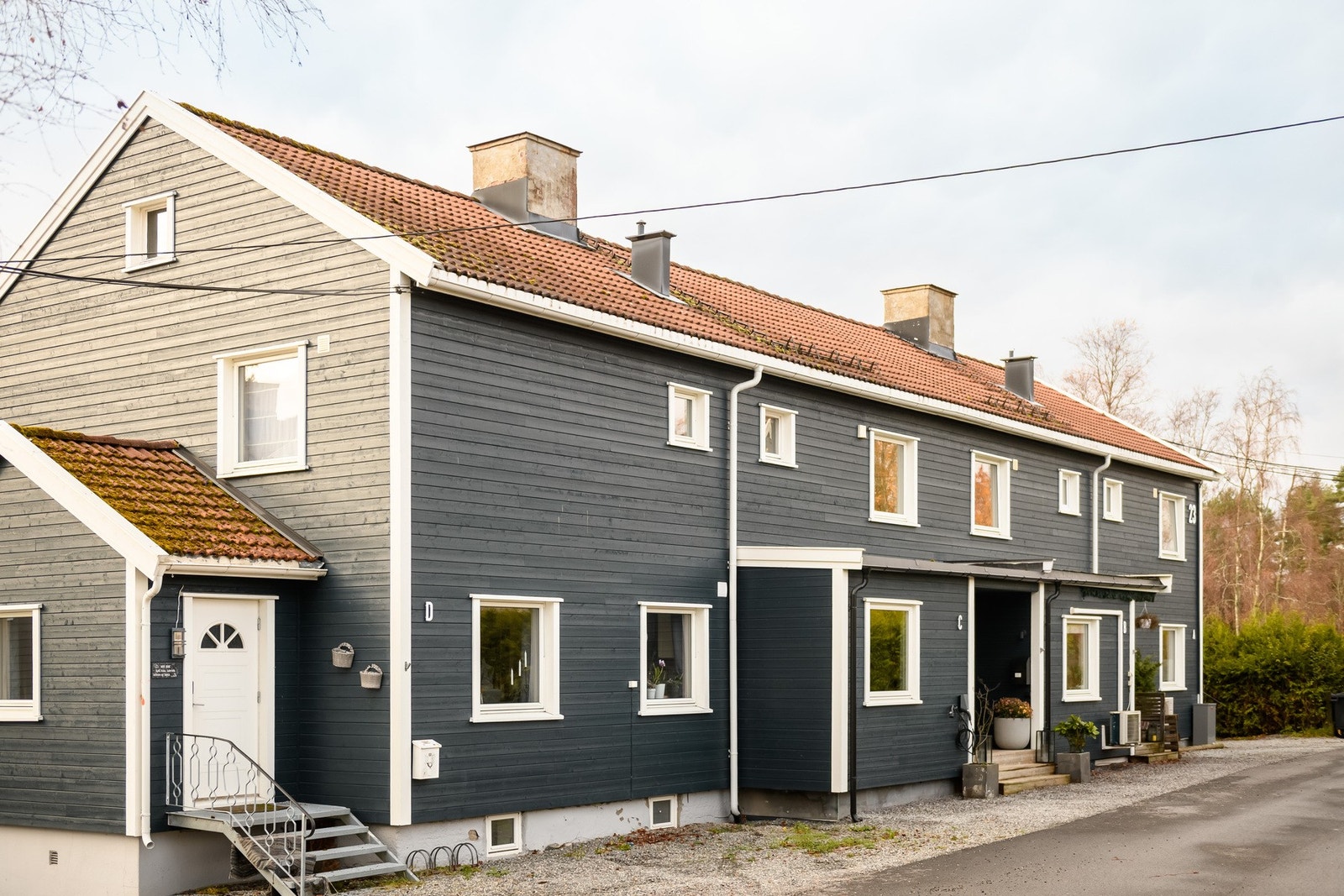 Overbygget inngangsparti gir en lun velkomst og praktisk skjerming mot vær og vind. Galleribilde