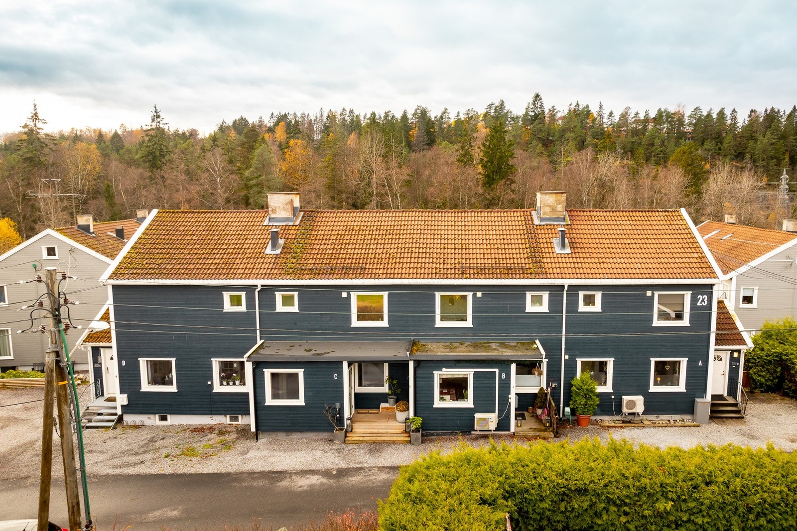 Sjarmerende rekkehusfasade med lune uteplasser og grønne omgivelser. Galleribilde