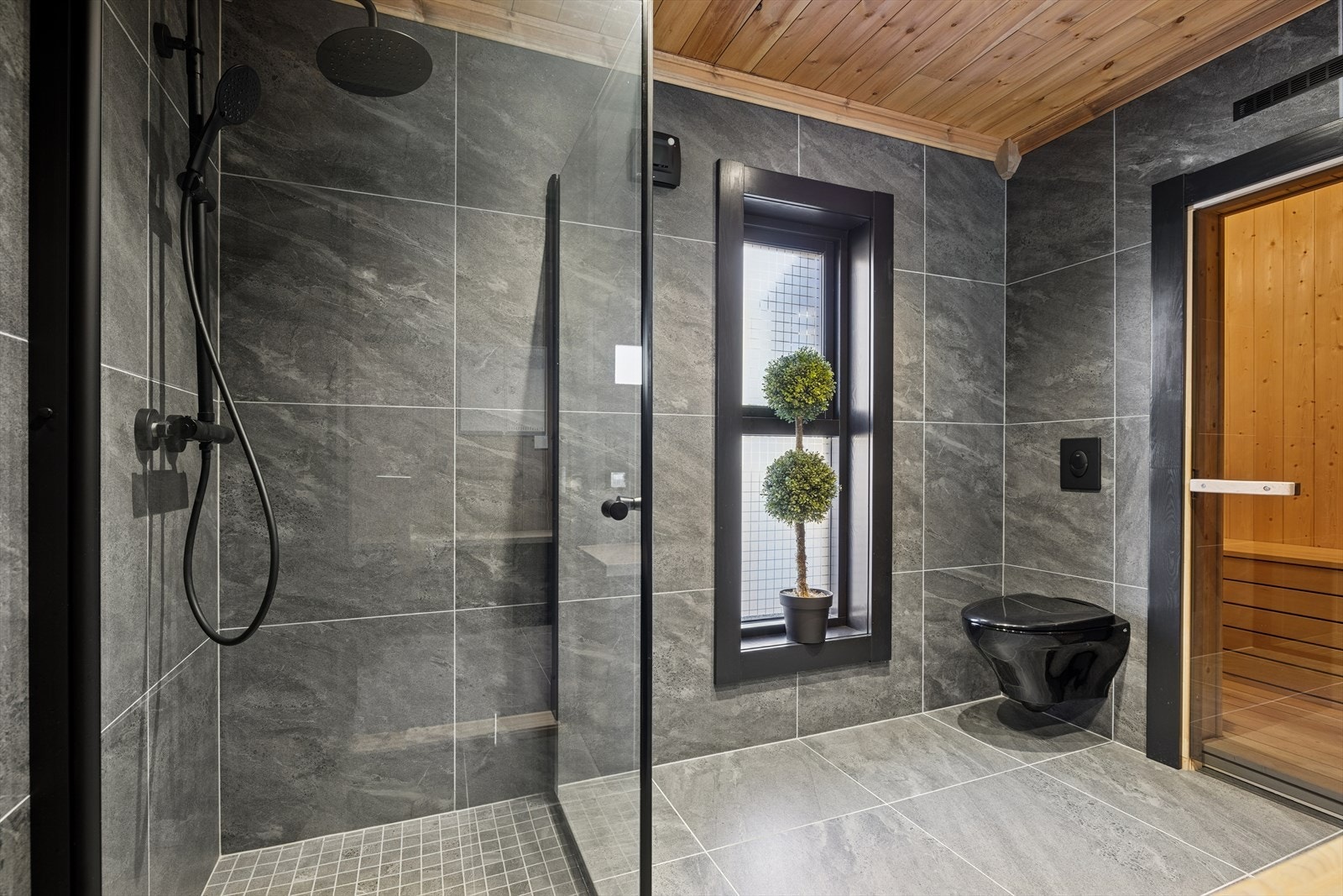 Badet i hovedetasjen har en tilpasset baderoms innredning med to servanter, dusjhjørne og vegg montert toalett. Galleribilde