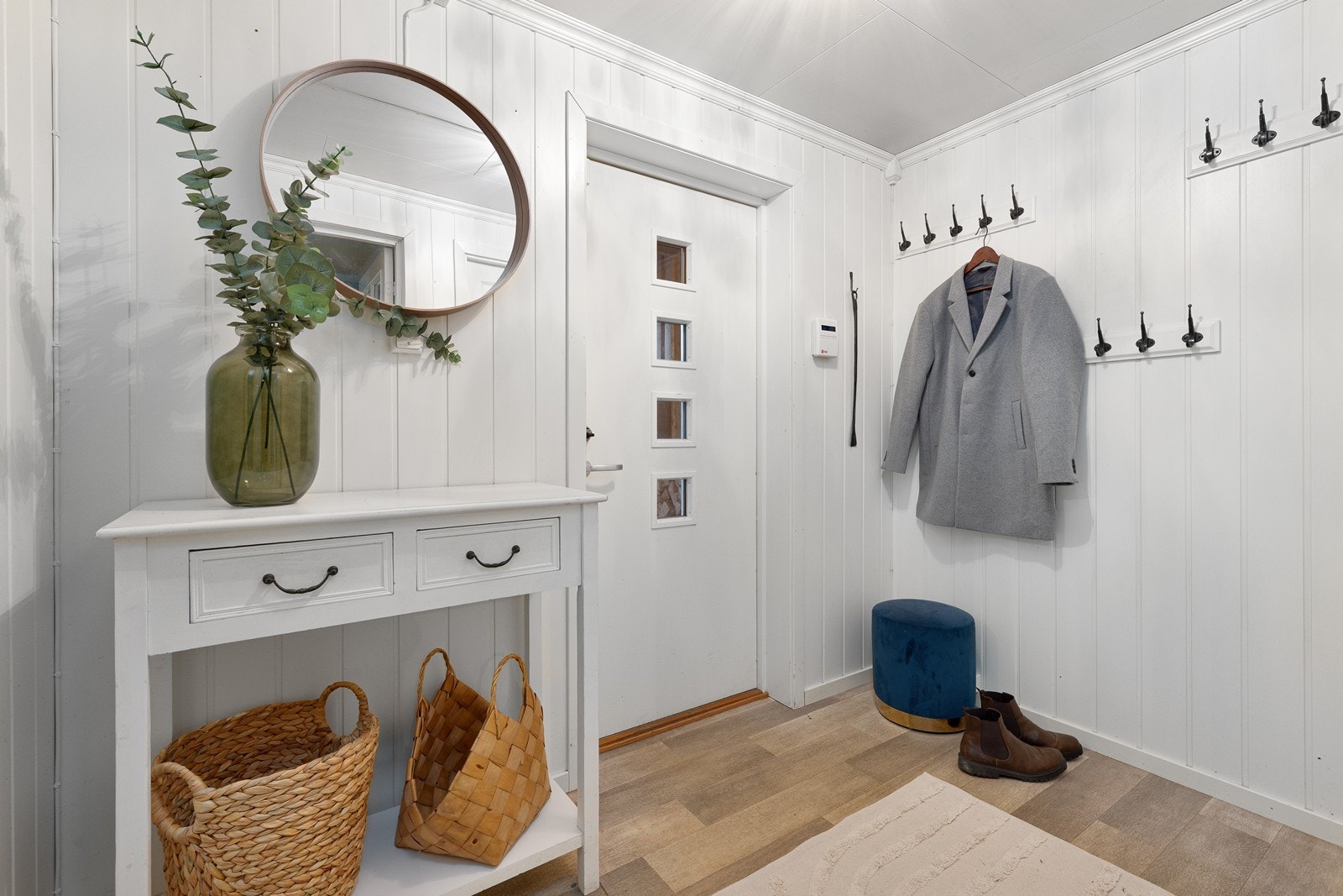 Velkommen inn! Den romslige entreen har plass til oppheng for yttertøy og til å sette ifra seg sko, noe som gjør det enkelt å holde orden i inngangspartiet. Galleribilde