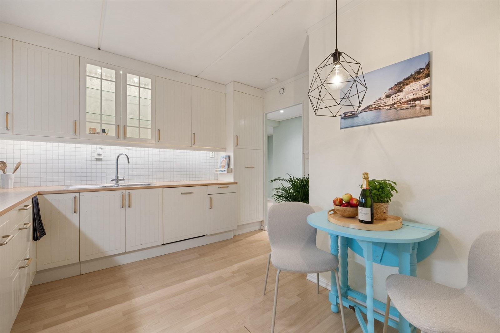 Kjøkken med hvit profilert utførelse og laminat benkeplate. Røropplegg, blandebatteri, kjøkkenventilator og PIE FlowStop (lekkasjesikring) fra 2019. Galleribilde