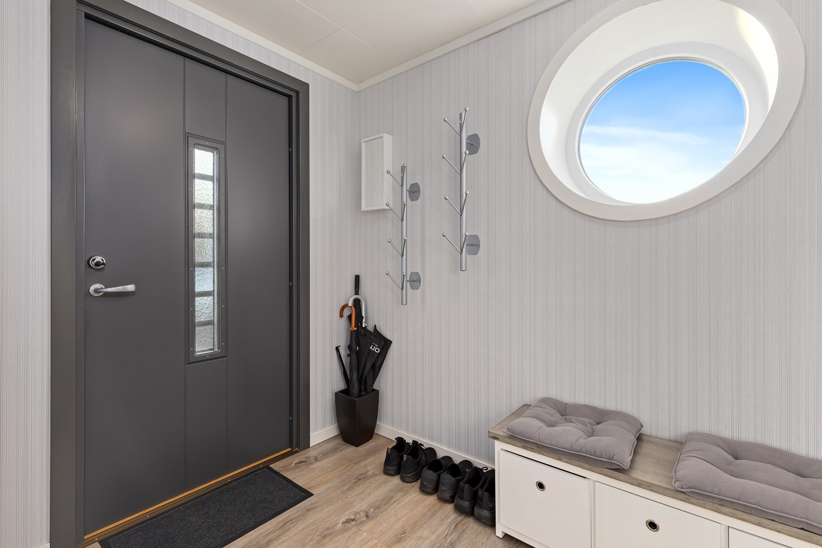 Romslig entrè med plass til sko og tøy. Nyere inngangsdør og rundt vindu. Galleribilde