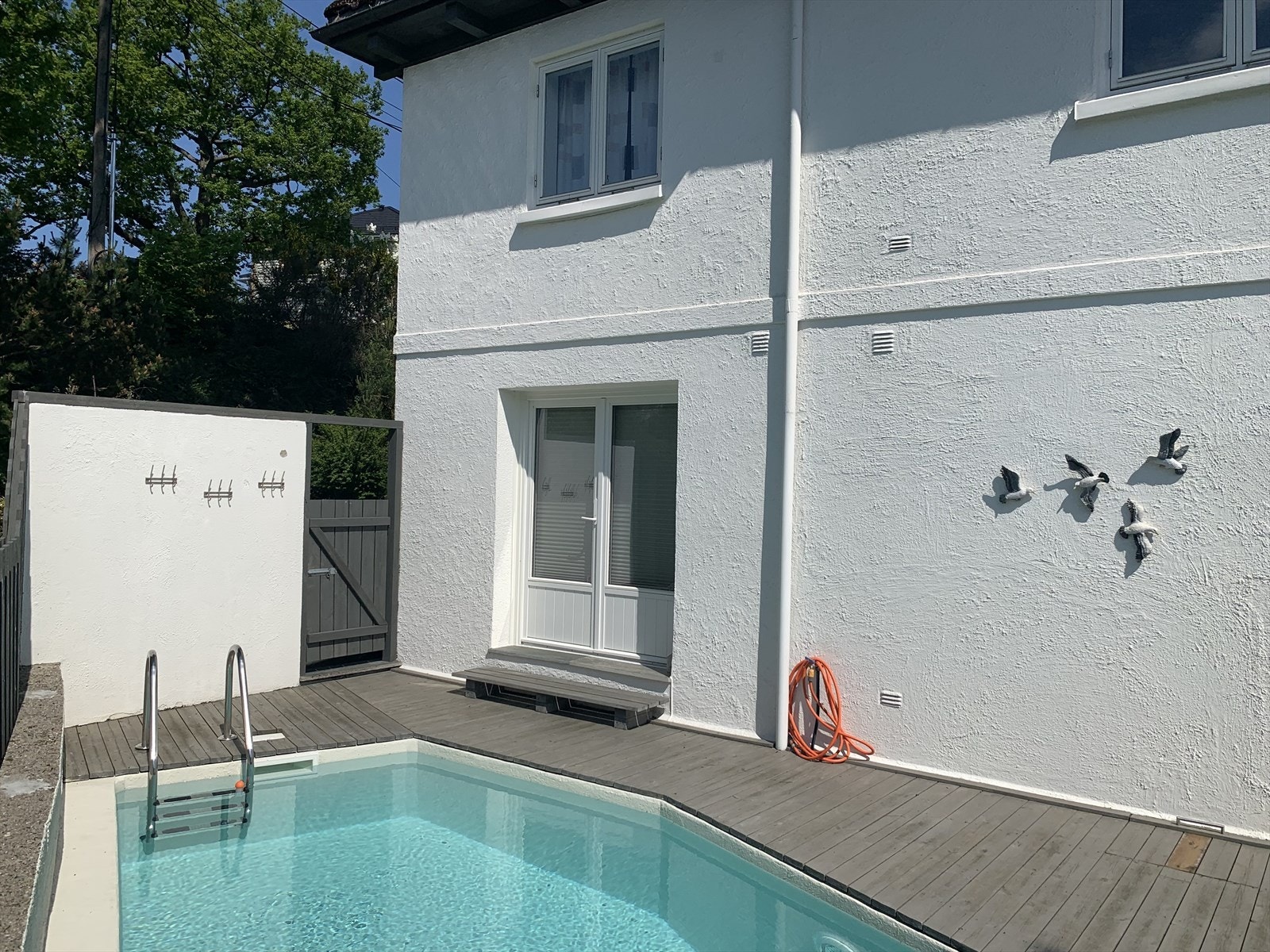 Privat bilde av terrasse med svømmebasseng. Dobbel balkongdør inn til del av stue Galleribilde