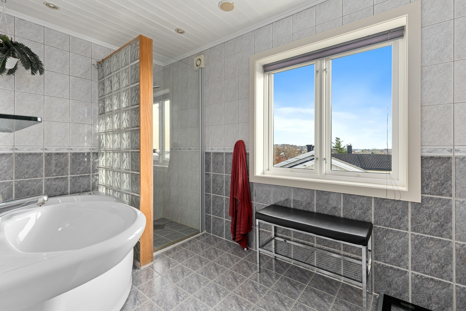 Badet er flislagt på gulv og vegger, og har vindu som slipper inn godt med naturlig lys Galleribilde