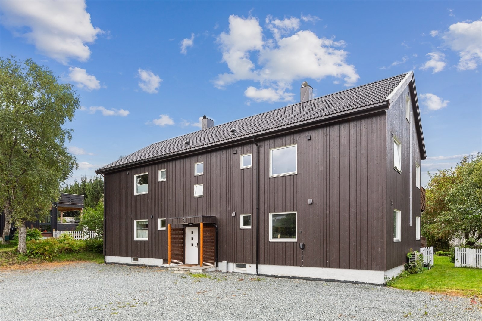 Foran inngangen har sameiet en felles gårdsplass for parkering. Boligen har montert elbillader. Galleribilde