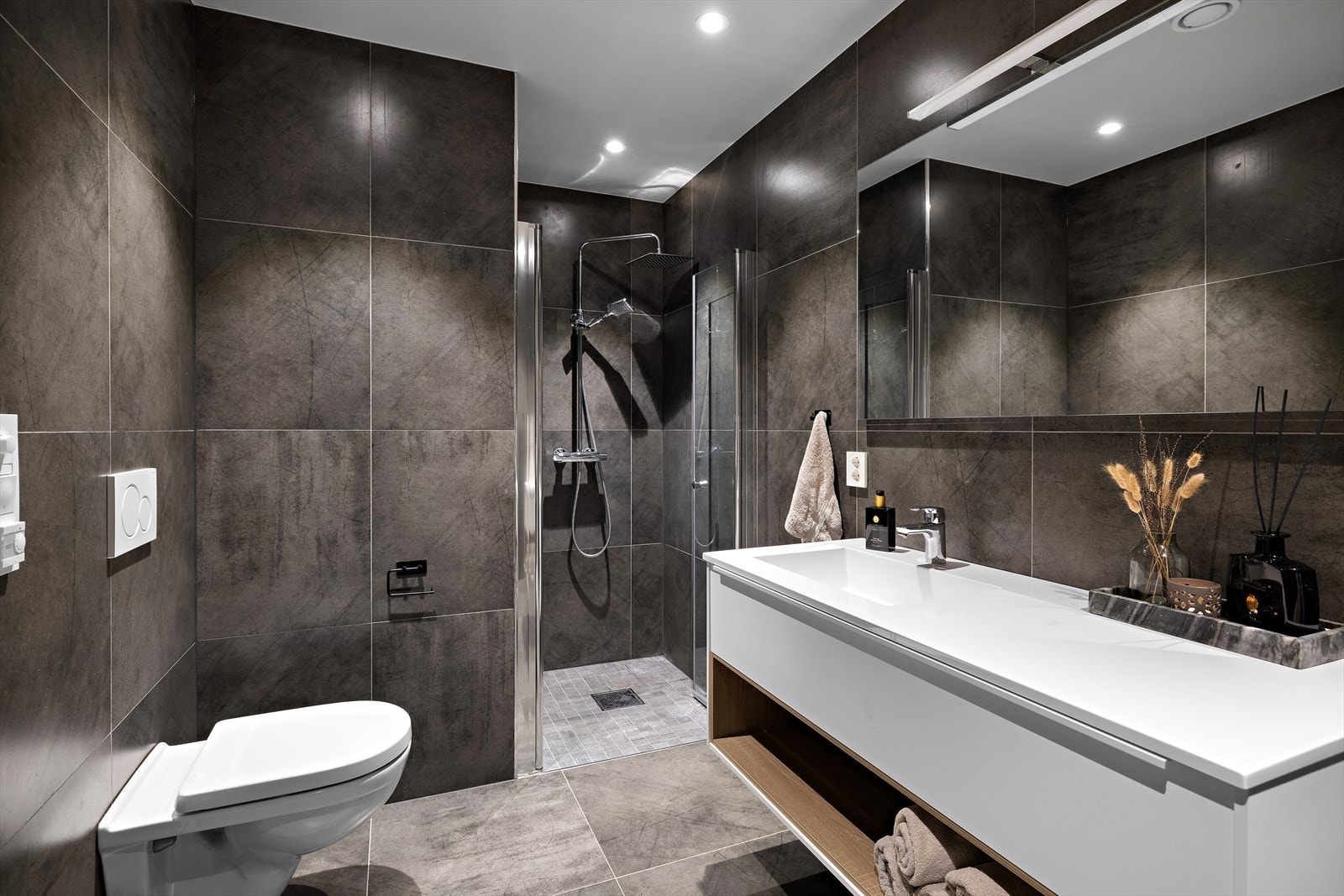 Badet i underetasjen er lekkert og moderne, med flislagt gulv, elektriske varmekabler og malt tak med downlights. Galleribilde