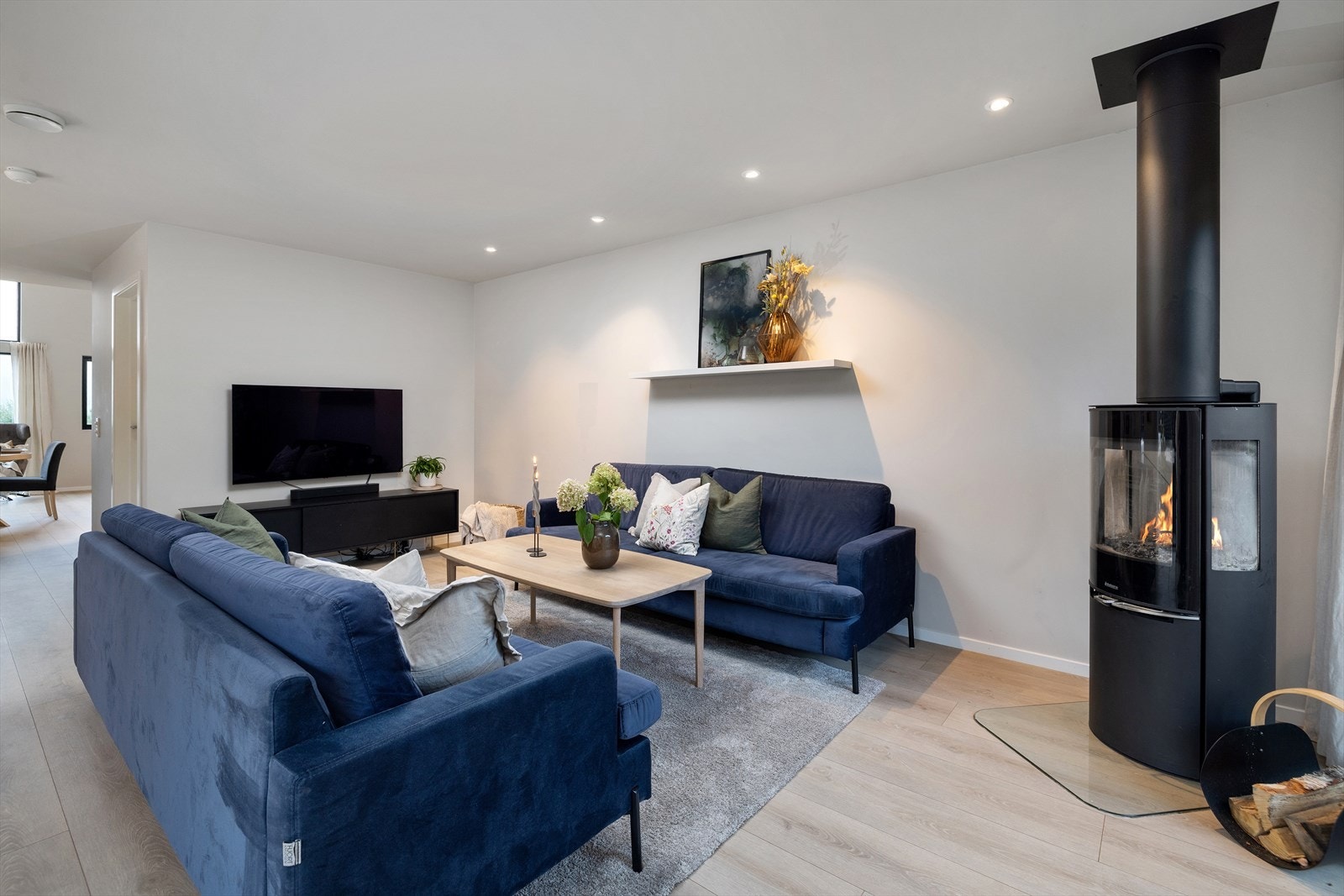 En moderne vedovn skaper både varme og hygge på kjølige dager, og downlights gir stemningsfull belysning. Galleribilde